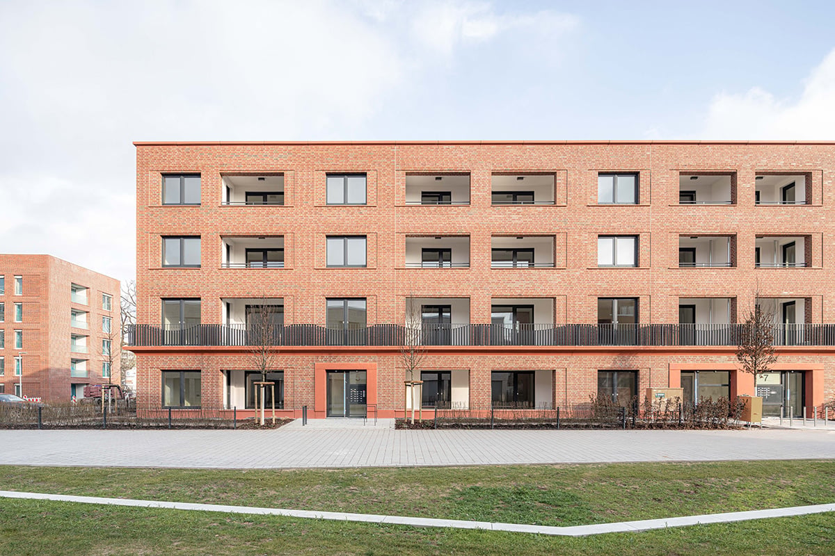 Der Riegel mit rotem Verblendmauerwerk bietet seinen Bewohnerinnen und Bewohnern an der Westfassade mit wettergeschützten Loggien und an der Ostfassade mit Balkonen individuellen Raum an der frischen Luft. 