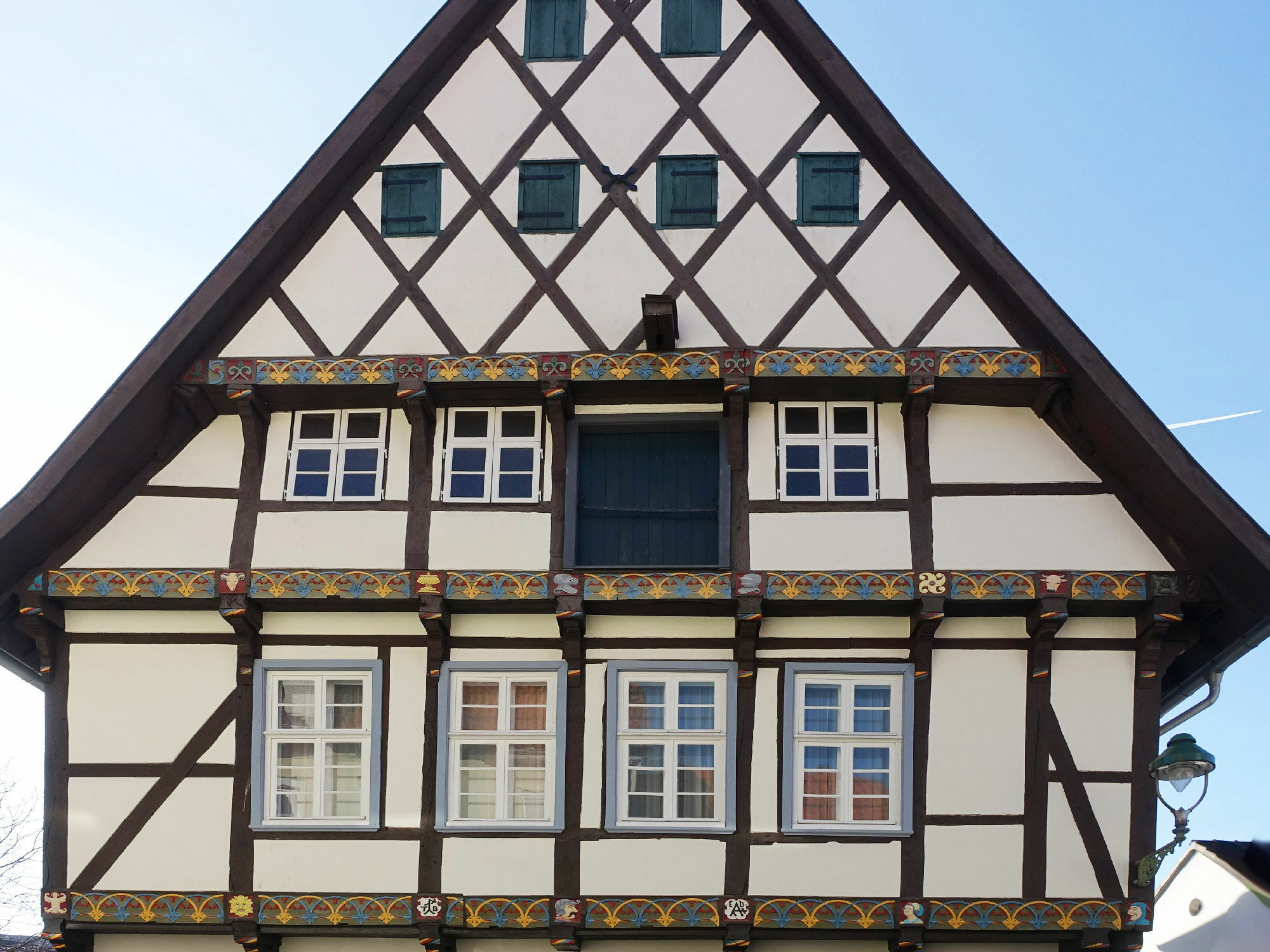 Mit einem Flaschenzug wurden die Güter entlang der Fassade in den Giebel hoch- und dann hineingezogen. Oft lässt sich noch der Haken oder ein auskragendes Schwert für die Befestigung des Flaschenzugs erkennen. Im Bild: Giebelluke eines Fachwerkhauses in Soest, Westfalen