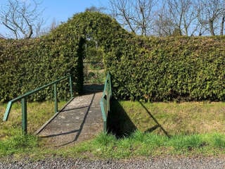 Gartentüren sind sowohl Elemente der Garten- und Landschaftsgestaltung als auch der Architektur mit dem Entrée, namentlich des Bereichs um die Eingangstür und der Fassade eines Hauses. Im Bild: Eine Cortenstahl-Tür kontrastiert eine Mauer aus Grünsandstein.
