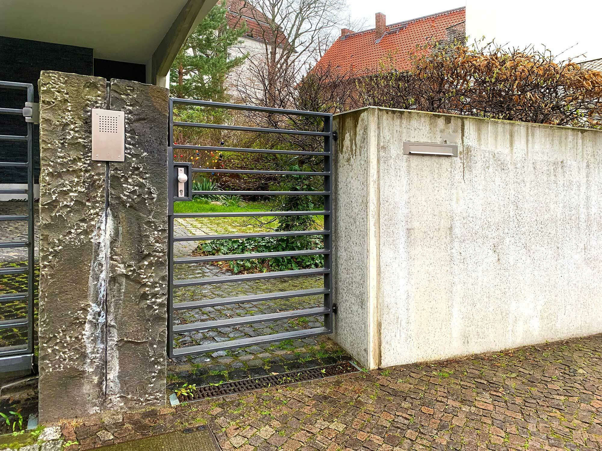 Falls eine Gartentür sozusagen ein Tandem mit der Hauseingangstür formt, ist sie durch die Hausnummer, Namensschild, Klingel, Gegensprechanlage und Beleuchtung zu ergänzen. 