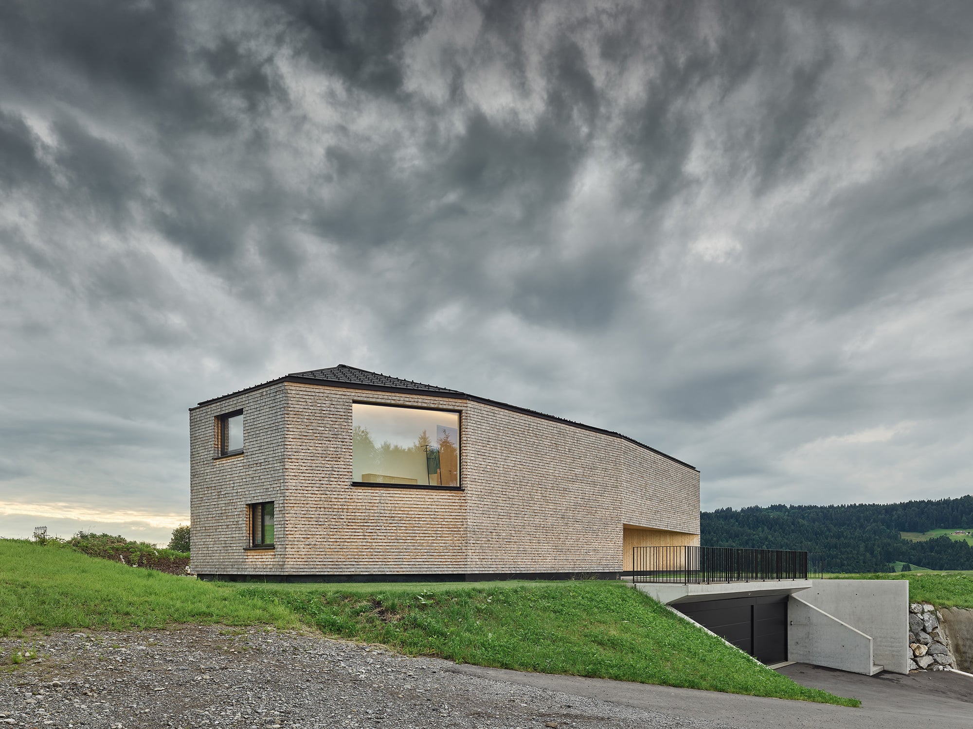 Großformatige Fenster brechen das filigrane Fassadenkleid auf und rahmen die Landschaft von innen. 