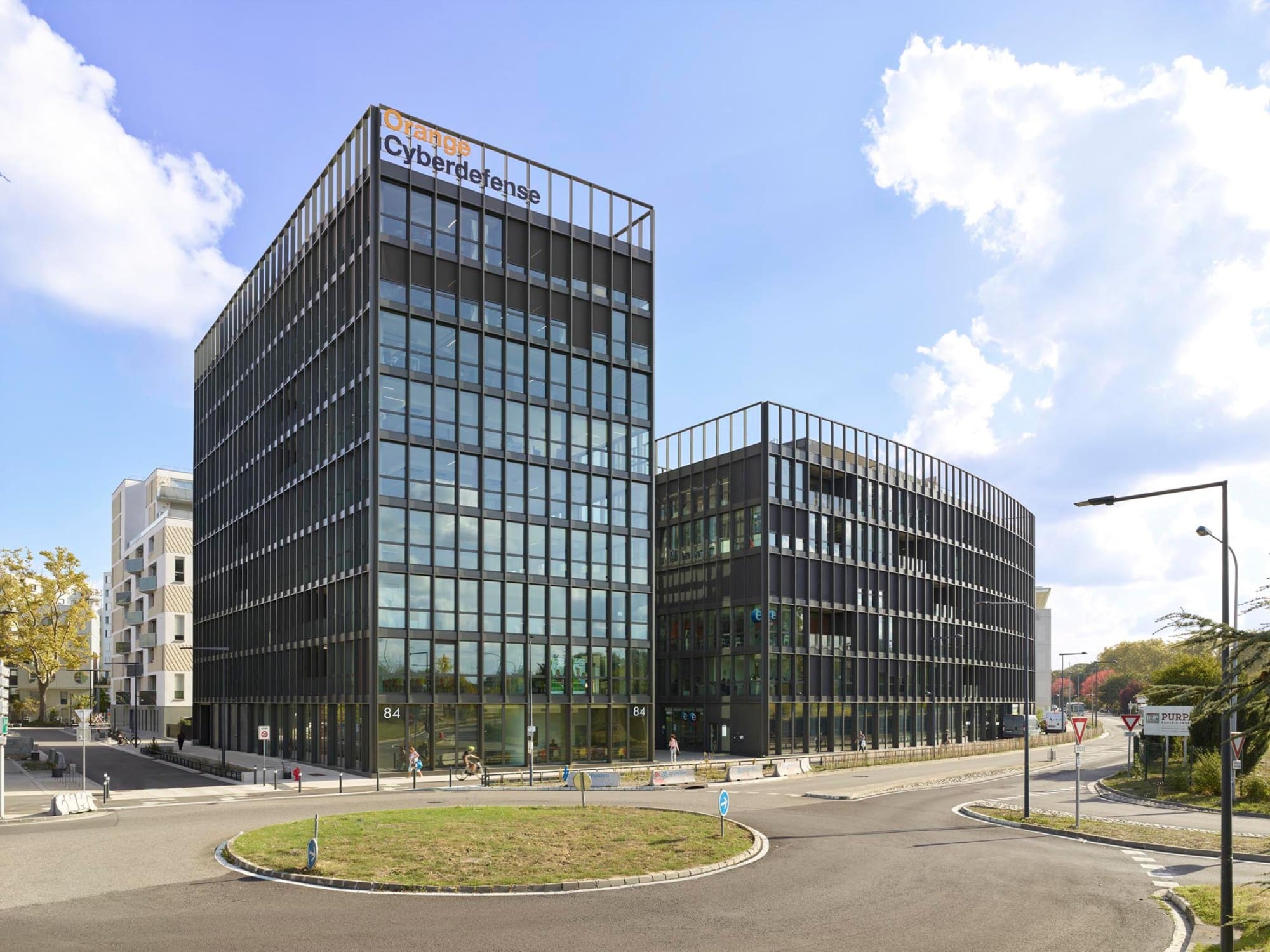 Gebäude B überragt das Gebäude A, welches mit geschwungenem Verlauf der Straße folgt und Richtung Eingangspassage weist.