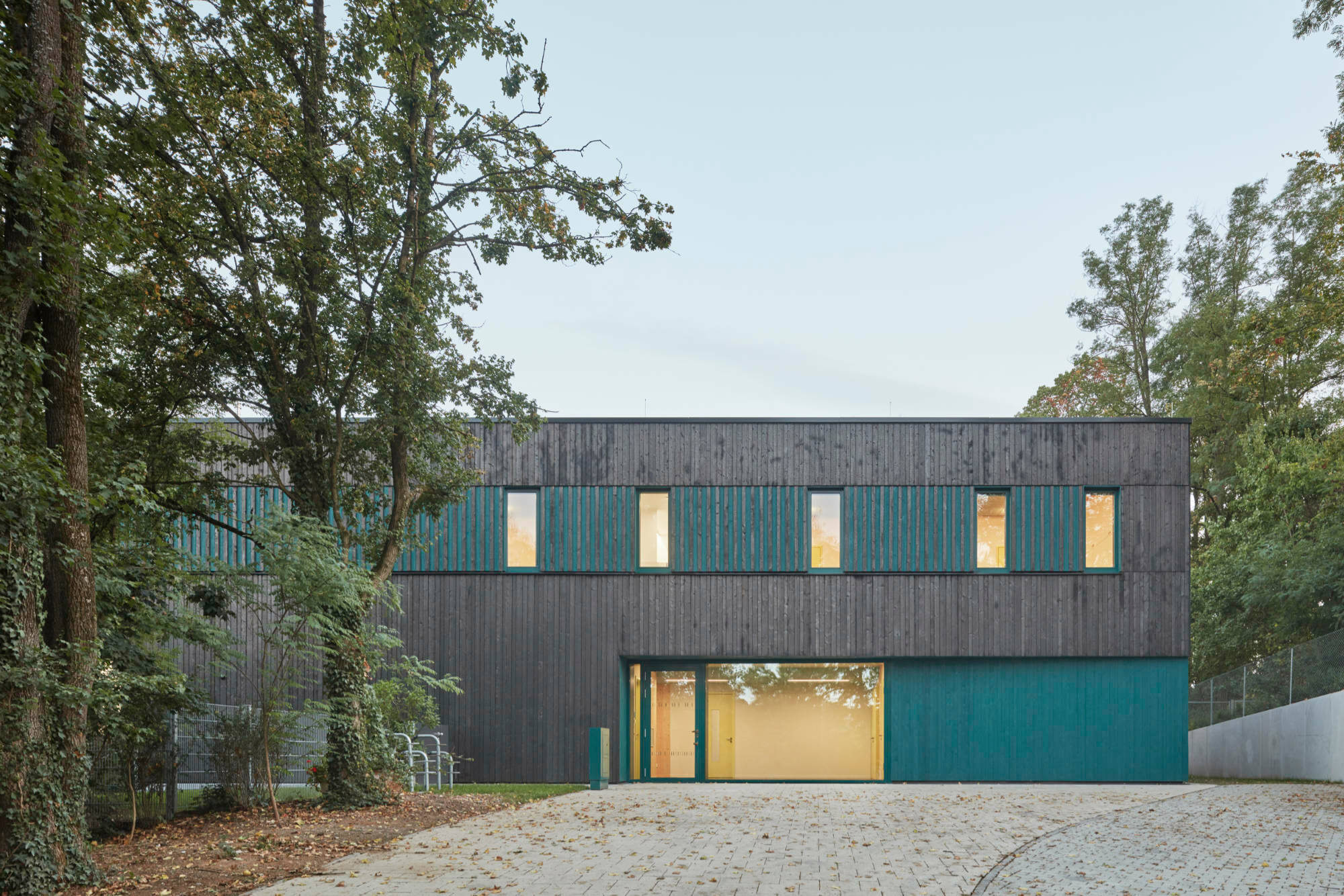 Im Kontrast zur Fassade aus schwarz geflammtem Fichtenholz sind bestimmte Bereiche blaugrün lasiert.