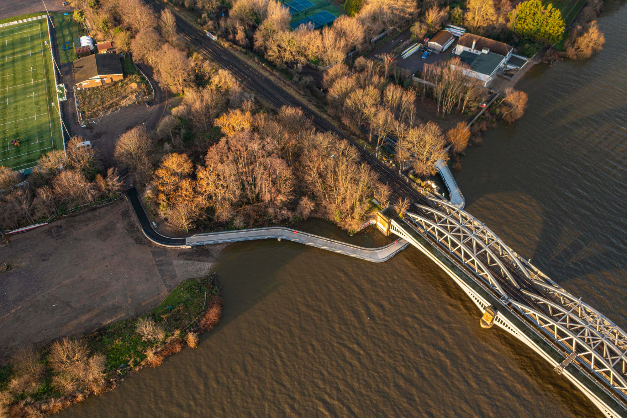 In eleganten Kurven umschwingt sie die Auflager der darüberliegenden Eisenbahnbrücke, der Barnes Bridge.