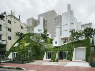Mit einem Anbau, der wie ein künstlicher Hügel gestaltet ist, haben Sou Fujimoto einen unscheinbaren Bestandsbau erweitert und zu einem Hotel umgebaut.