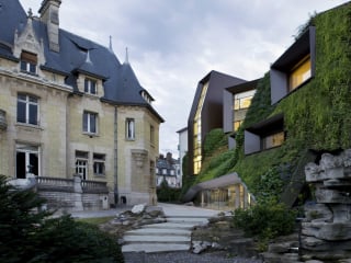 Rechts die Erweiterung mit der dicht begrünten Fassade, links der Altbau