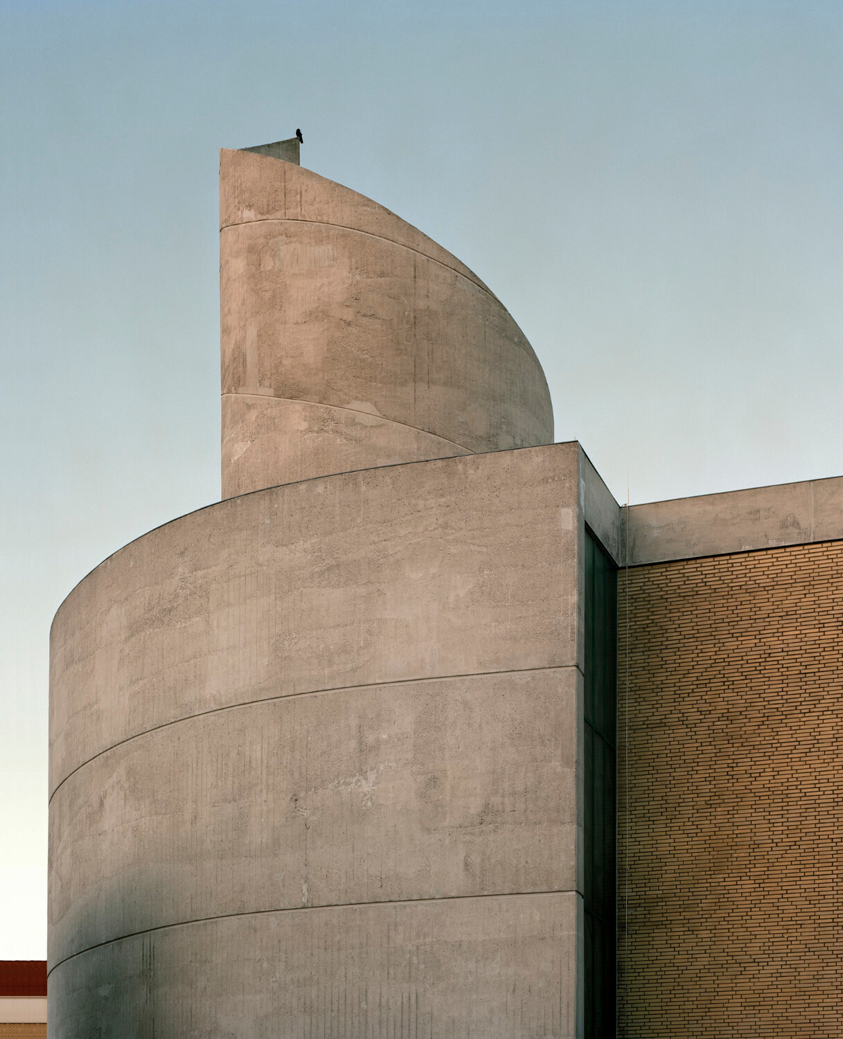 Der in den 1970er-Jahren errichtete Bau fällt durch seinen schneckenhausartigen Sichtbetonturm auf.