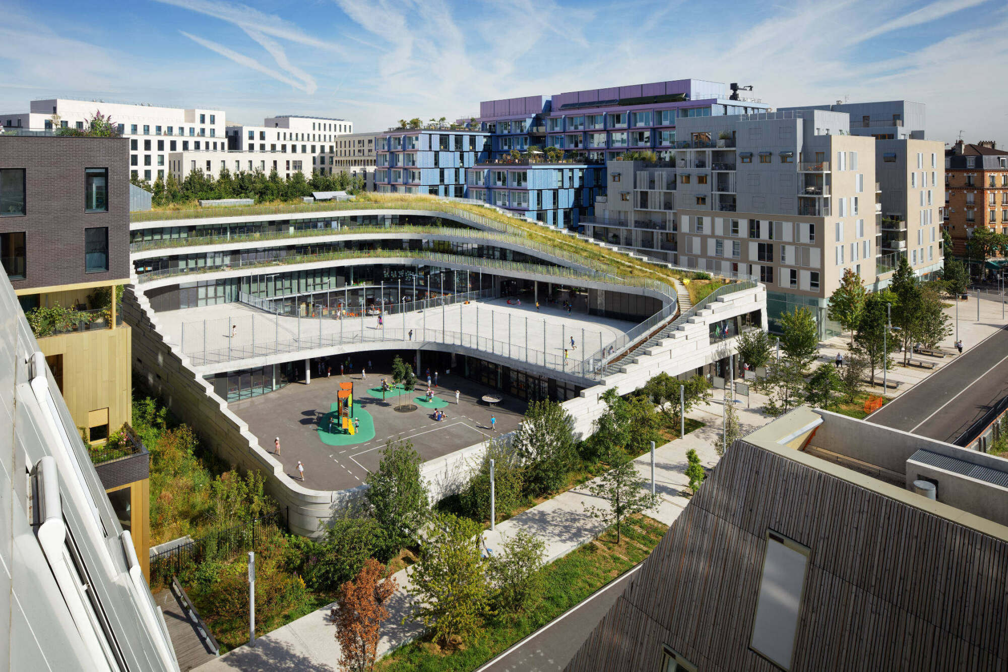Eingefasst wird der Gebäudekomplex von einer unregelmäßigen Mauer, die an zwei Seiten den Schulhof begrenzt und an den anderen beiden Seiten die Außenfassade bildet.