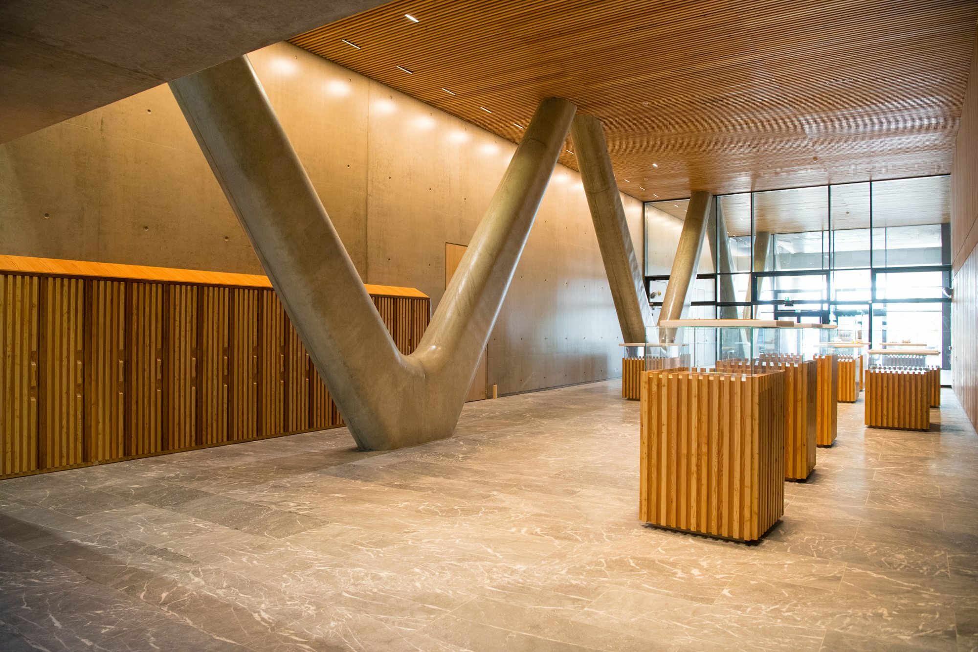 Holz, Glas und Sichtbeton bilden die Raumhülle innen. Die markanten V-Stützen wurden  ebenfalls gestaltet.