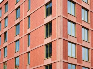 Der sechsgeschossige Hotelbau, entworfen vom Münchner Architekturbüros Hild und K, sticht mit einer roten Beton-Ziegelfassade hervor.