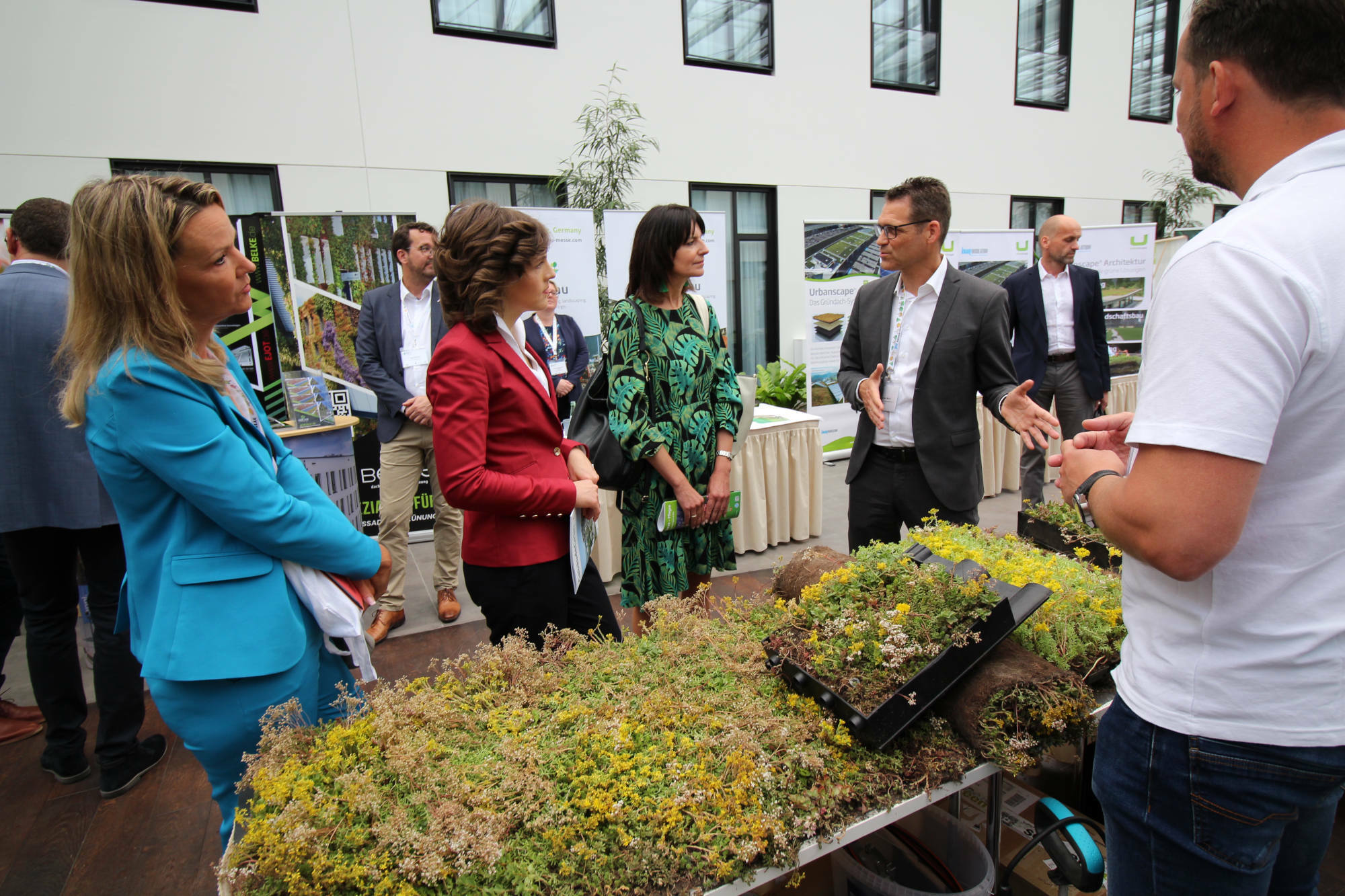 Interessierte Politik beim Weltkongress: BuGG-Präsidenten Dr. Gunter Mann (rechts) führt durch die Messe und informiert die Staatssekretärin Dr. Britta Behrendt (Berliner Senatsverwaltung für Umwelt, Mobilität, Verbraucher- und Klimaschutz, gleich daneben) und die Parlamentarischen Staatssekretärin Elisabeth Kaiser (Bundesministerium für Wohnen, Stadtentwicklung und Bauwesen, in rot).