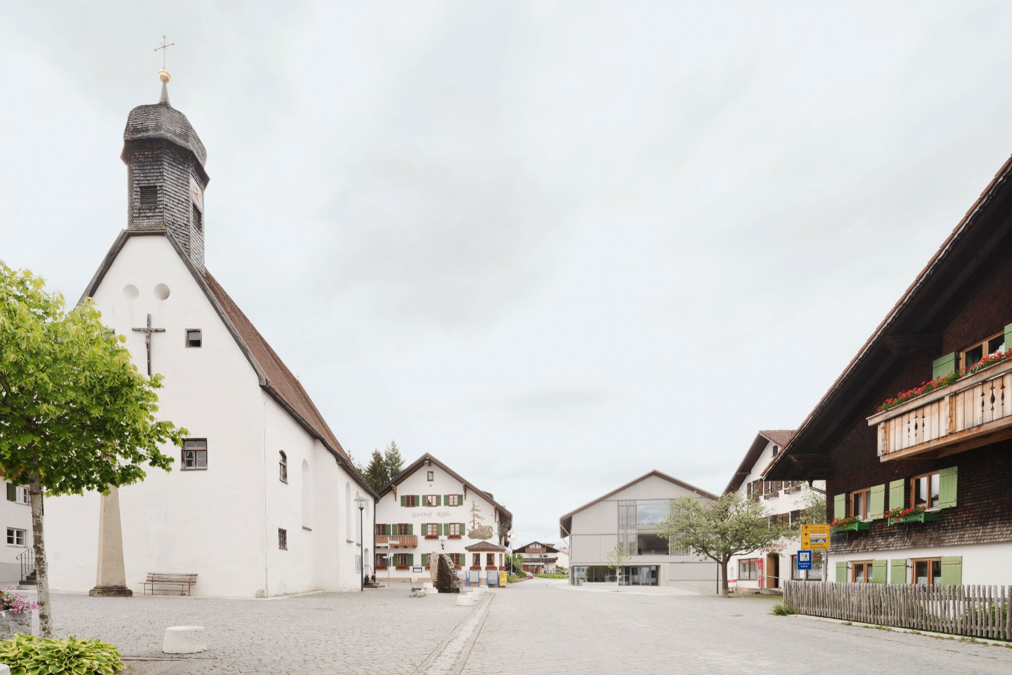Gemeinsam mit der historischen Kirche rahmt das Rathaus den Dorfplatz.