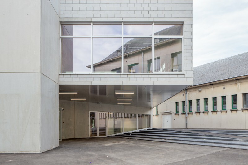 Neben dem Eingangsbereich an der Südseite befindet sich ein der Fassade vorgesetzter Fahrstuhlschacht aus Sichtbeton, der Hof und Fassade als eigener Körper mitgestaltet. 
