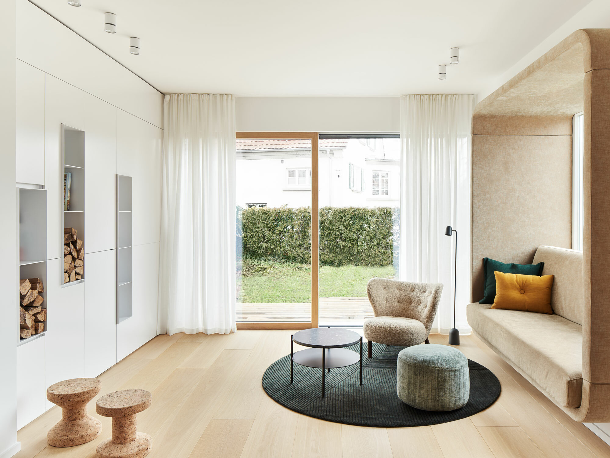 Statt klassischen Sofas gibt es im Wohnzimmer eine behagliche Sitznische, die mit den Holzdielen harmoniert. 