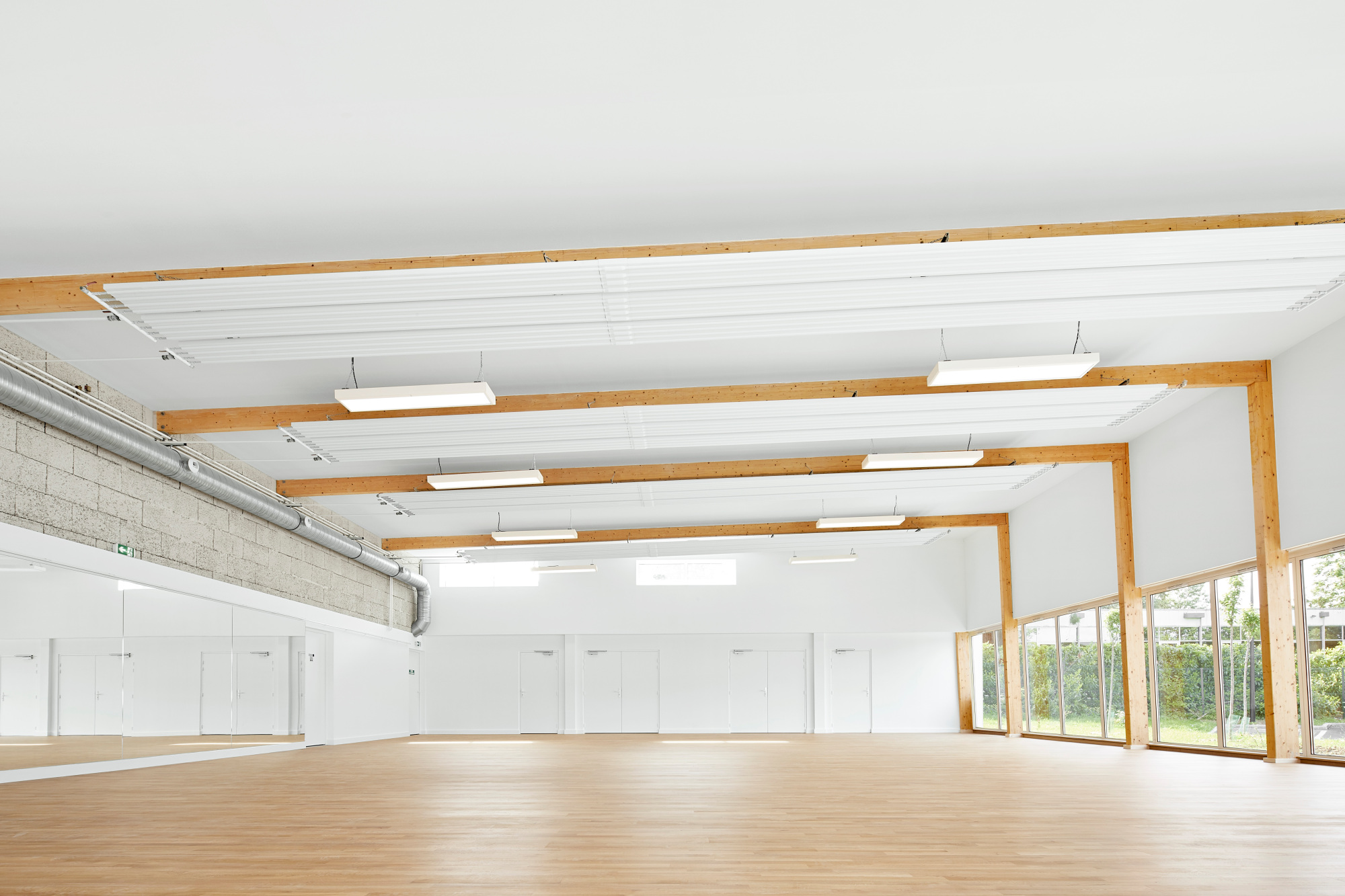 Die Massivholzträger liegen auf einer rückwärtigen Wand aus Hanfbetonblöcken und schaffen Platz für die Ausübung von Sportarten.