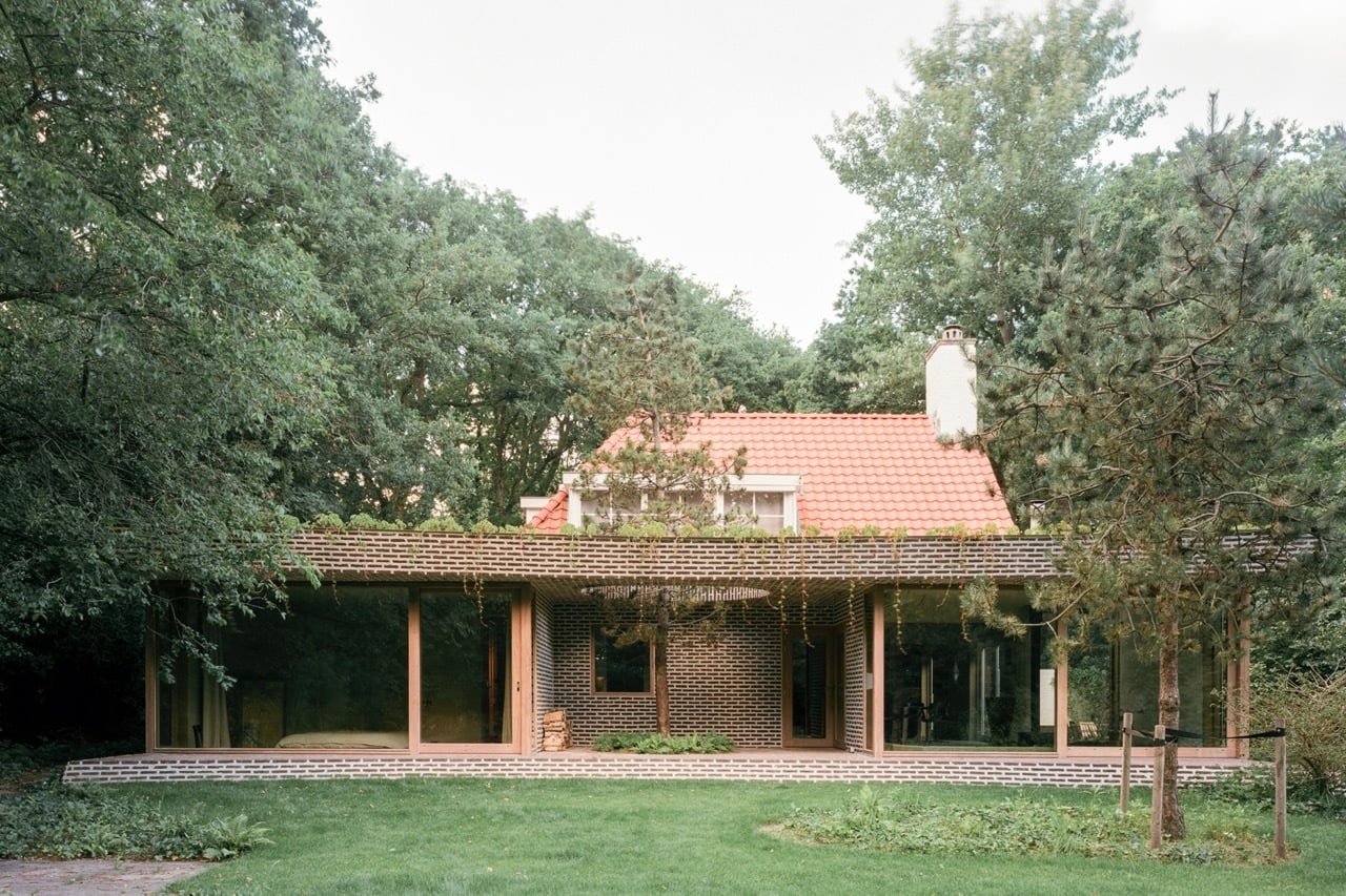 ... während gartenseitig ein eingeschossiger, geschwungener Anbau aus braunem Backstein in reduzierter, zeitgemäßer Formensprache eine neue architektonische Schicht hinzufügt.