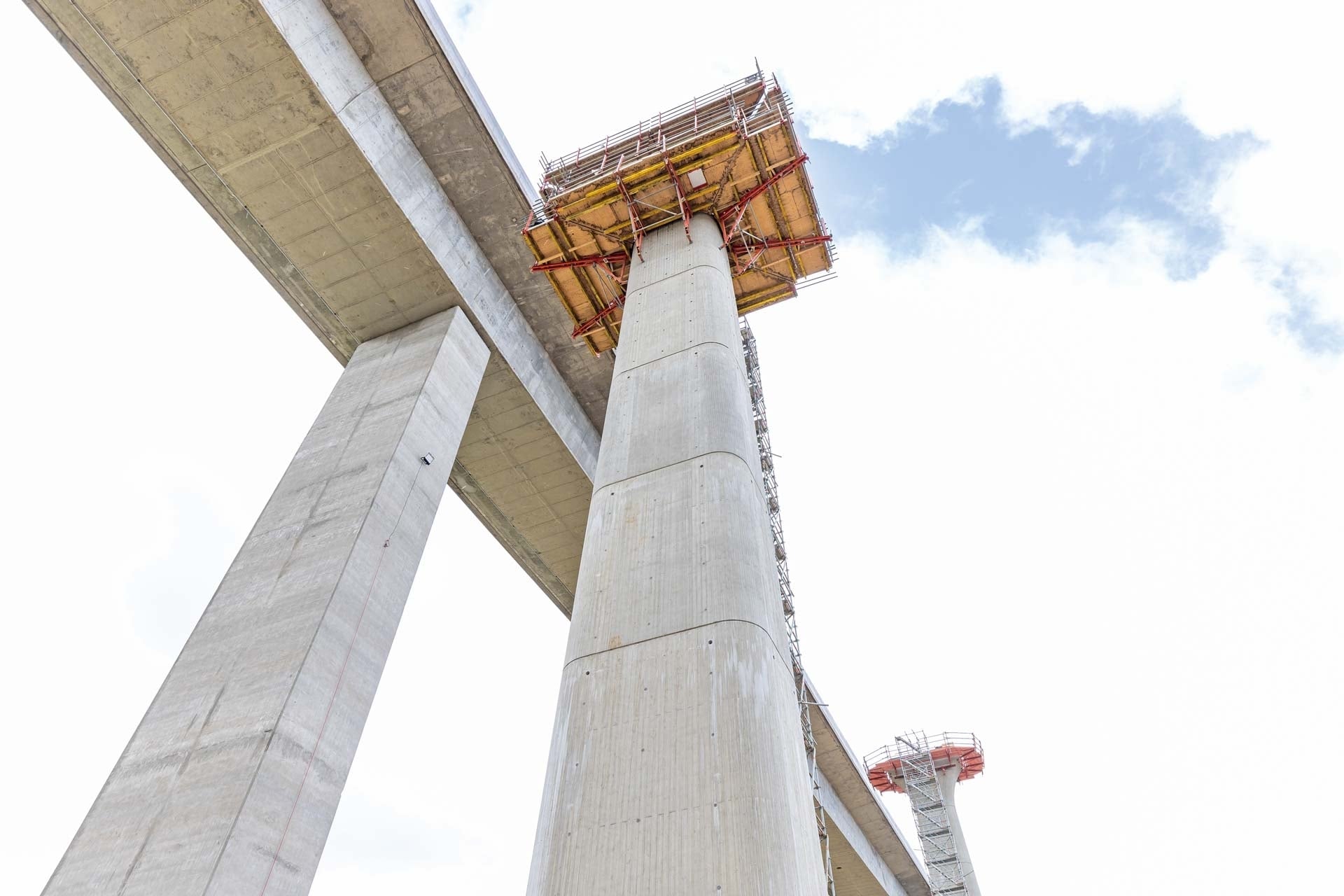 Die bis zu 36,5 Meter hohen Brückenpfeiler weisen Sichtbetonqualität und eine aufwendige Geometrie mit sich nach oben verschlankendem Schaftquerschnitt auf.