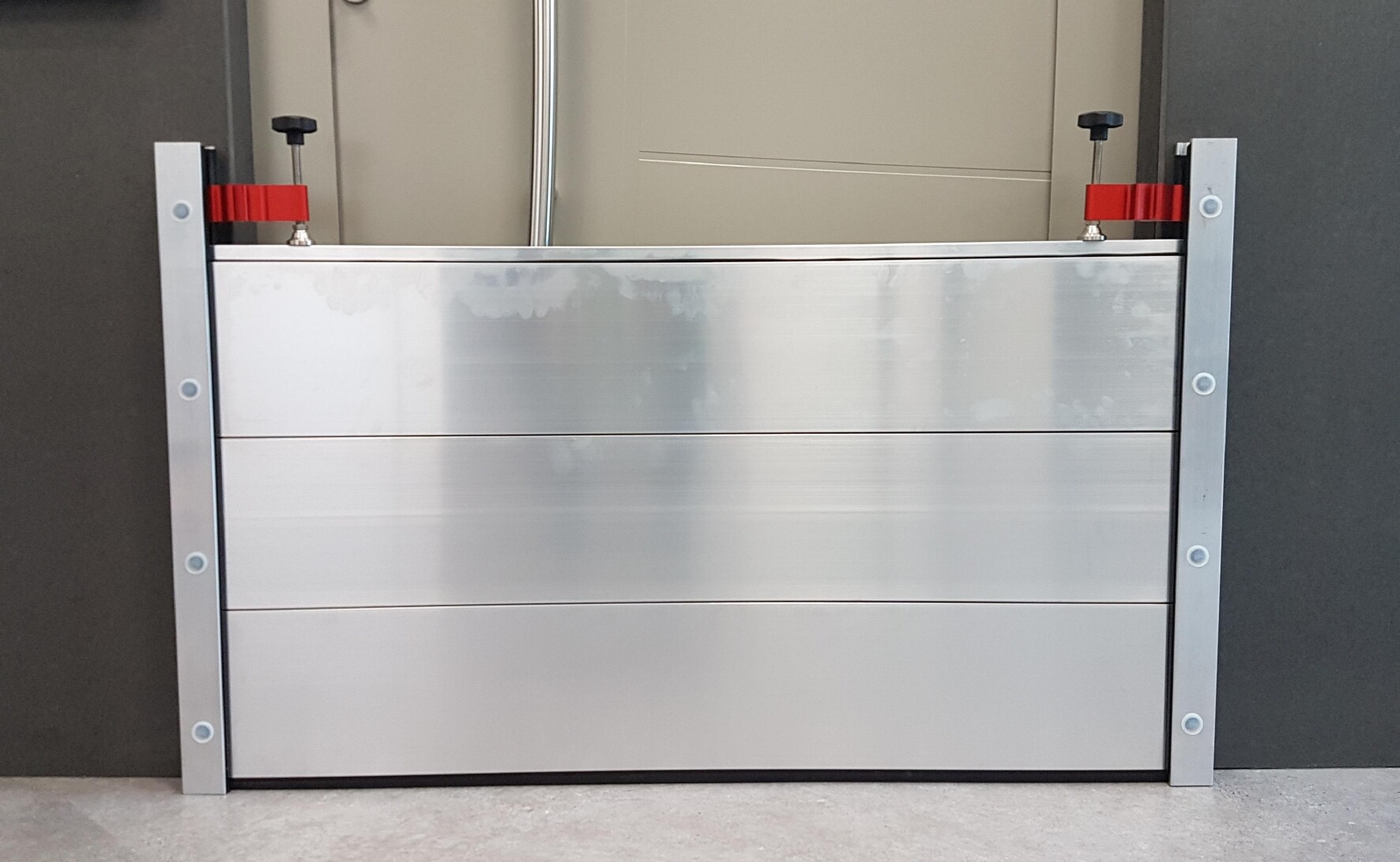 Beim Objektschutzsystem werden Befestigungsprofile fest in der Wand oder in der Mauer installiert. Bei akuter Hochwassergefahr werden die Dammbalken aus Aluminium beidseitig in die Befestigung eingeschoben und mit einem Spannstück montiert.