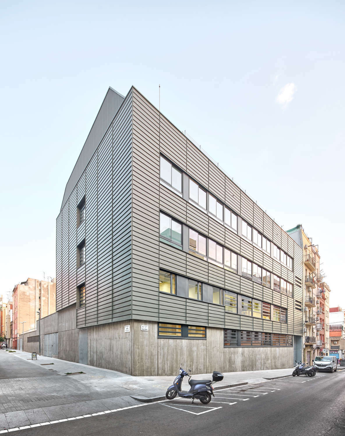 Der Entwurf stammt von Sumo Architectes und MIM-Architectes. Eine hinterlüftete Fassade aus graugrünen Zinkblechen mit horizontaler Ausrichtung hüllt oberhalb des Sockels die gesamte Fassade ein.