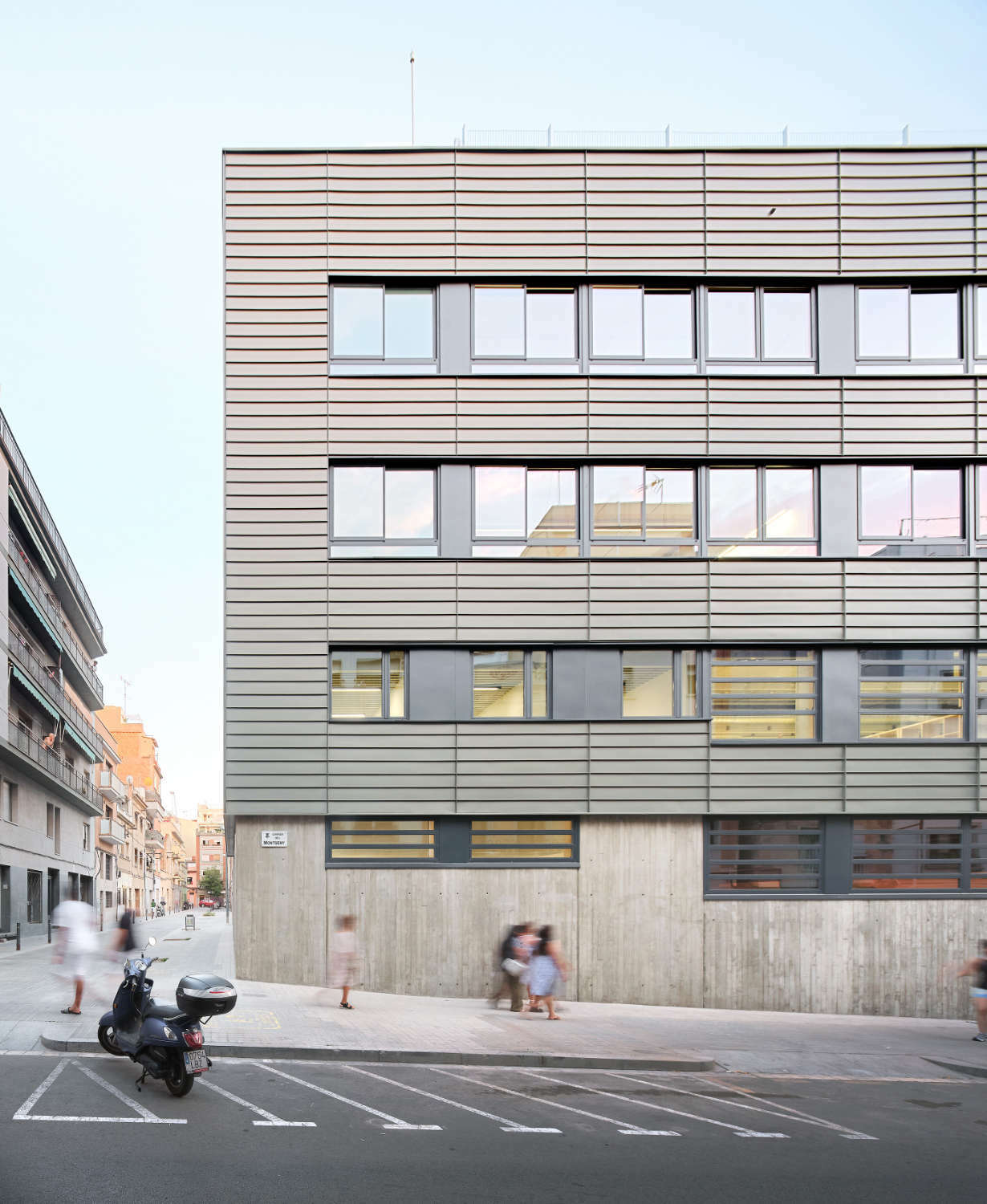 Das Gebäude schmiegt sich an den Rand eines Eckgrundstücks, das an eine Hauptstraße und eine autofreie Gasse grenzt.