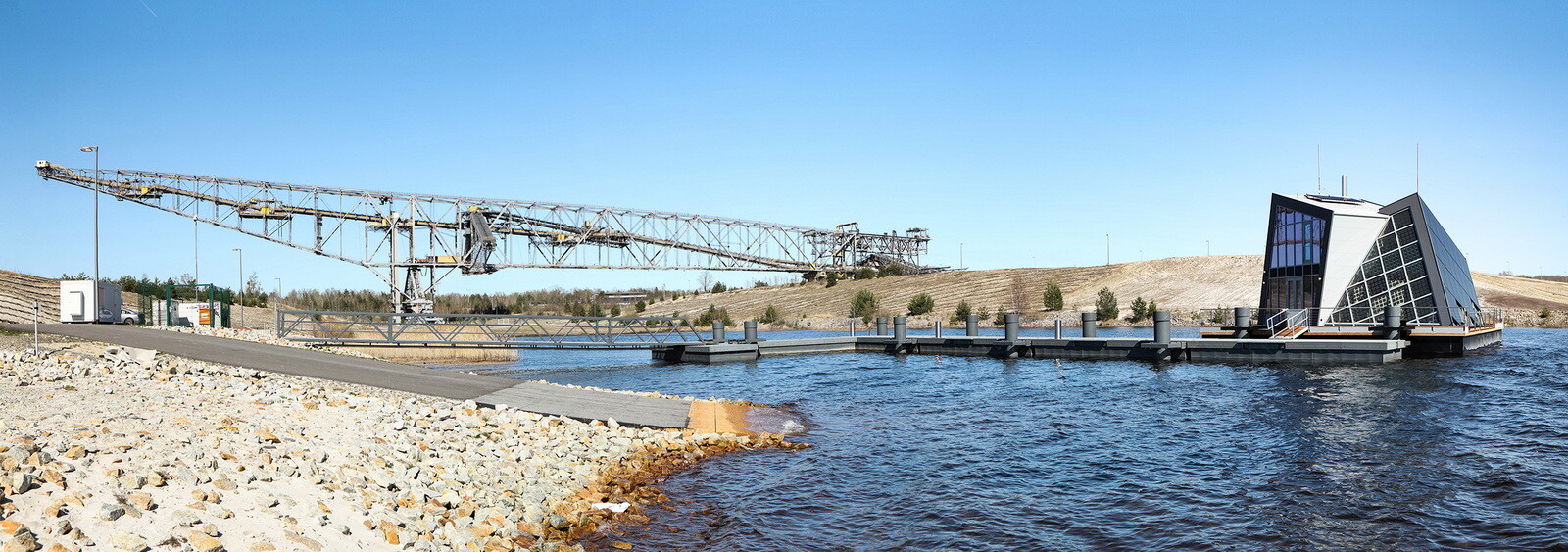 Zu Füßen der ehemaligen Abraumförderbrücke F60: Der Liegeplatz vom Ponton-Haus ist der Hafen im Bergheider See, der durch Rekultivierung eines Lausitzer Braunkohlereviers entstanden ist.
