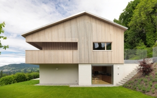 Während die Grundform des zweigeschossigen Gebäudes am Genfersee nahezu unverändert blieb, erhielt das Volumen bei der umfassenden Renovierung durch Graber & Petter Architectes eine neue Hülle aus vertikalen Holzlamellen.
