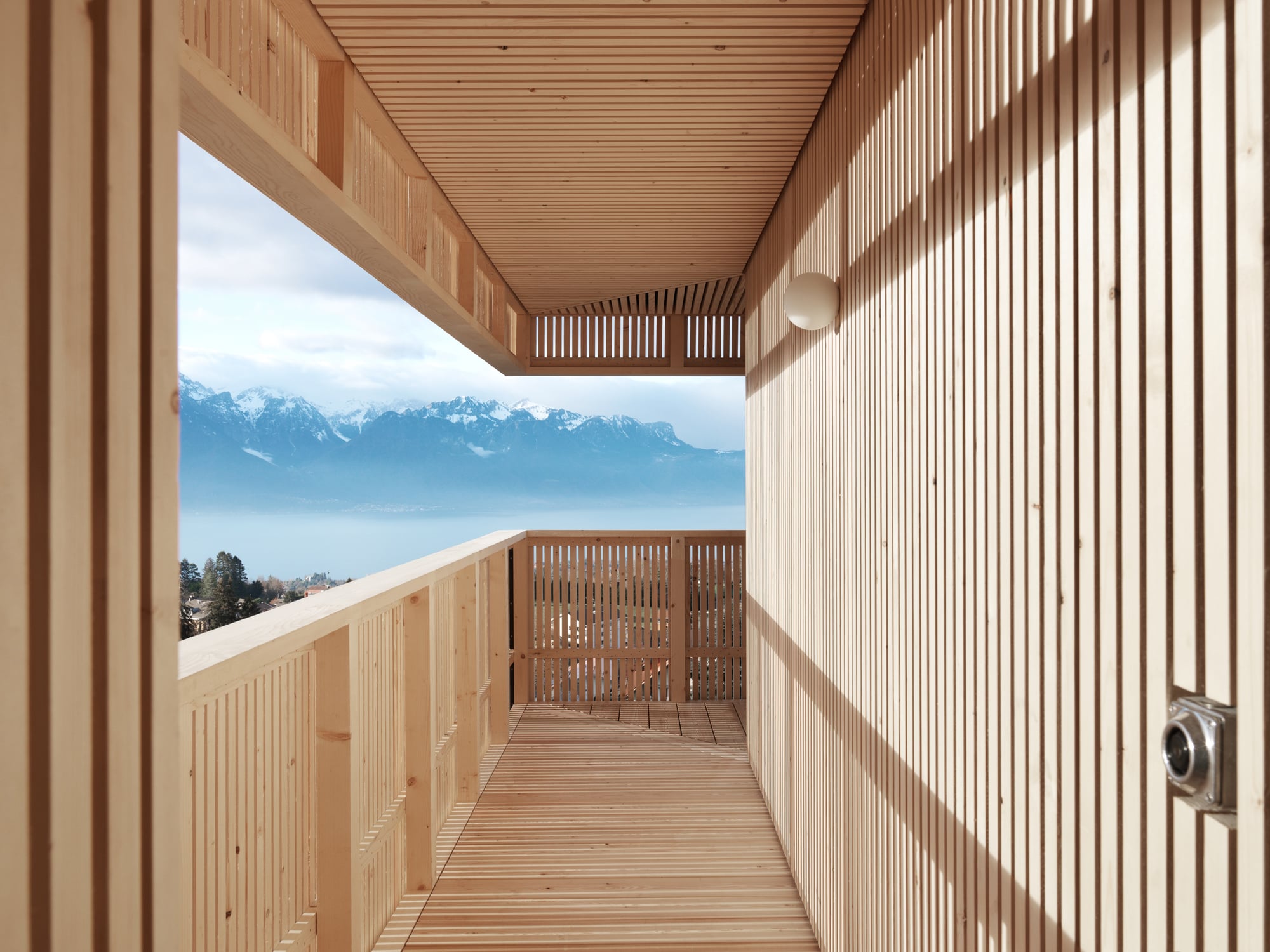 "Die Holzverkleidung integriert die verschiedenen Öffnungen und nimmt den vorhandenen Balkon auf, so dass er wie das Deck eines Schiffs zu einer Erweiterung der Innenräume wird", erklären die Architekten Raphaël Graber und Yann Petter das Konzept.