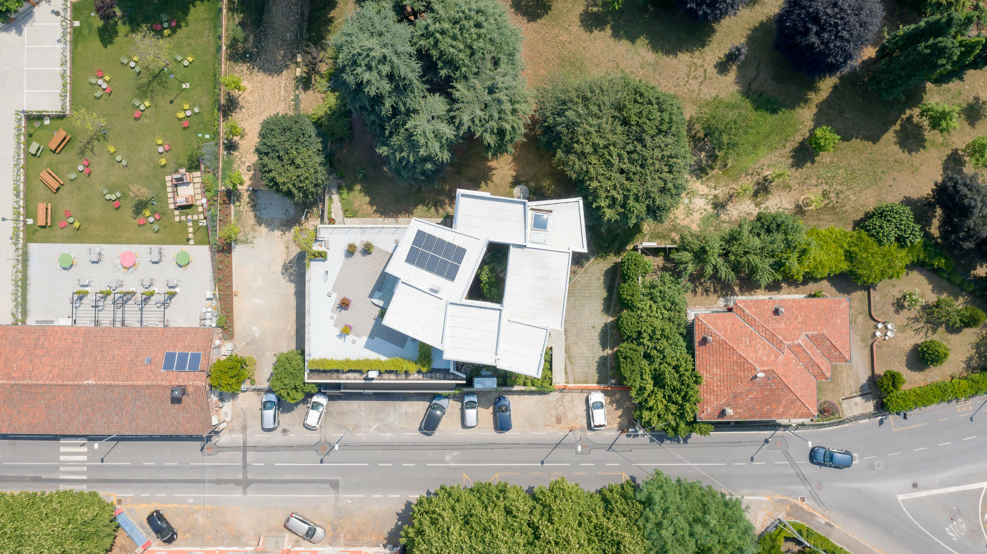 Umgeben ist das Wohnhaus von heterogener Bebauung und altem Baumbestand.