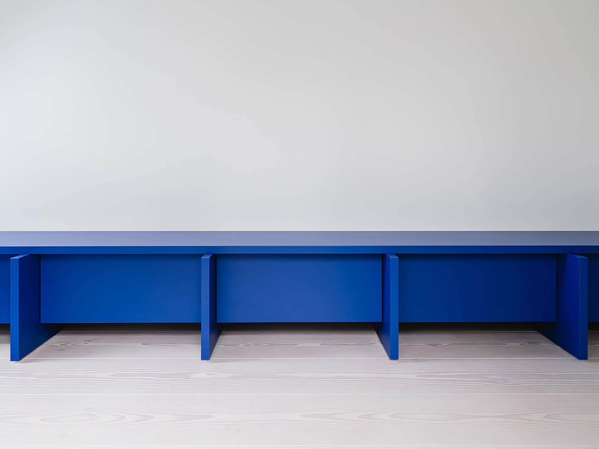 Ein kräftiges Blau bringt farbliche Kontraste ins helle Interior. Die maßgefertigten Möbeleinbauten sind ...