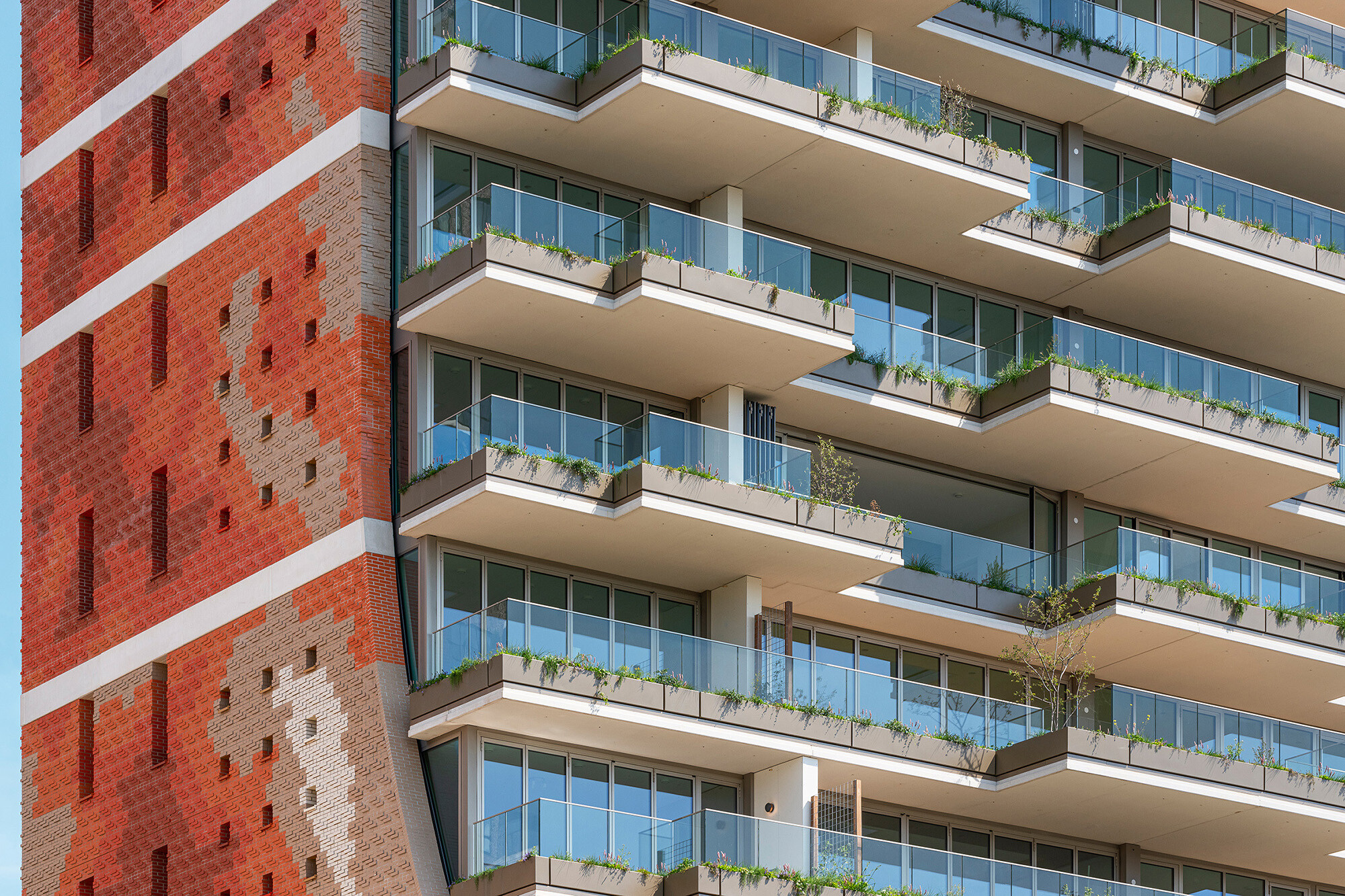 Nach Süden sieht das Gebäude völlig anders aus, denn hier staffeln sich begrünte Balkone und Dachterrassen mit raumhohen Glaswänden. Diese Staffelung hat im Querschnitt die Kontur einer halbierten Parabel, die viel Belichtung ermöglicht.