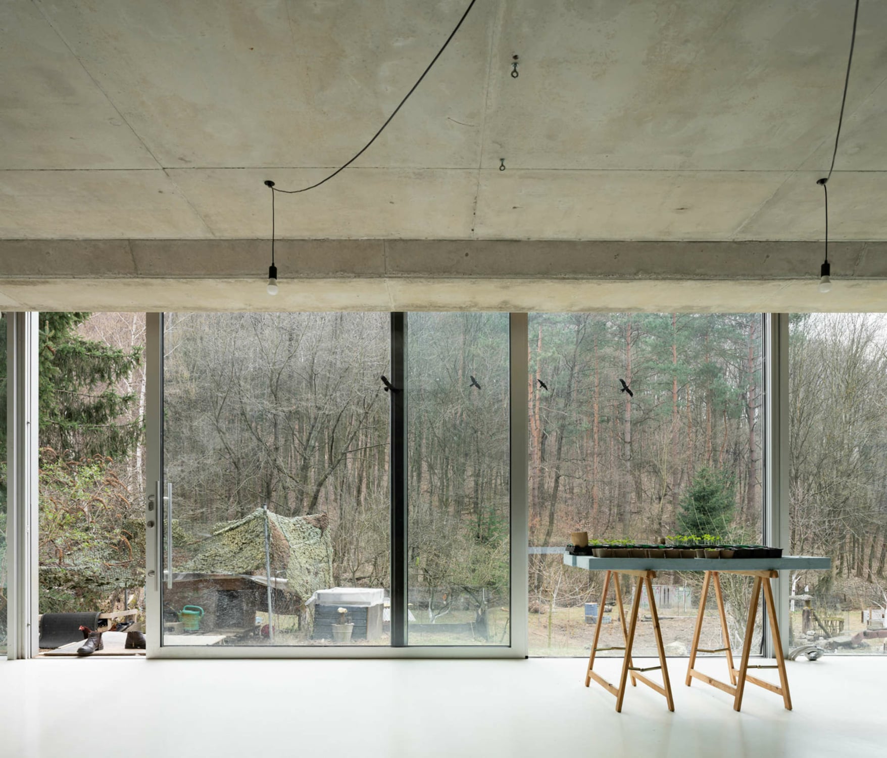 Diese raum- respektive haushohe Fensterfläche erweitert nicht nur visuell die Innenräume, sondern bietet einen unverstellten Blick auf die hügelige Landschaft der Umgebung.