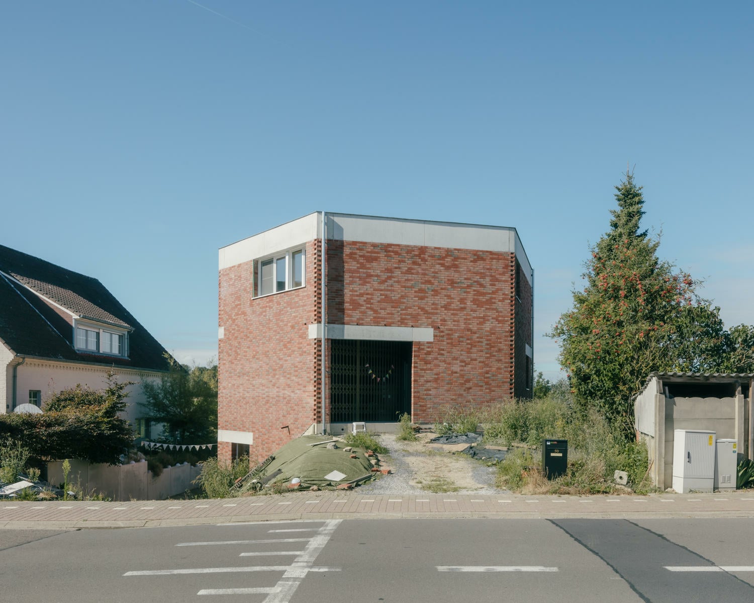 Mit nur wenigen straßenseitigen Fassadenöffnungen zeigt sich das Haus introvertiert und reduziert.