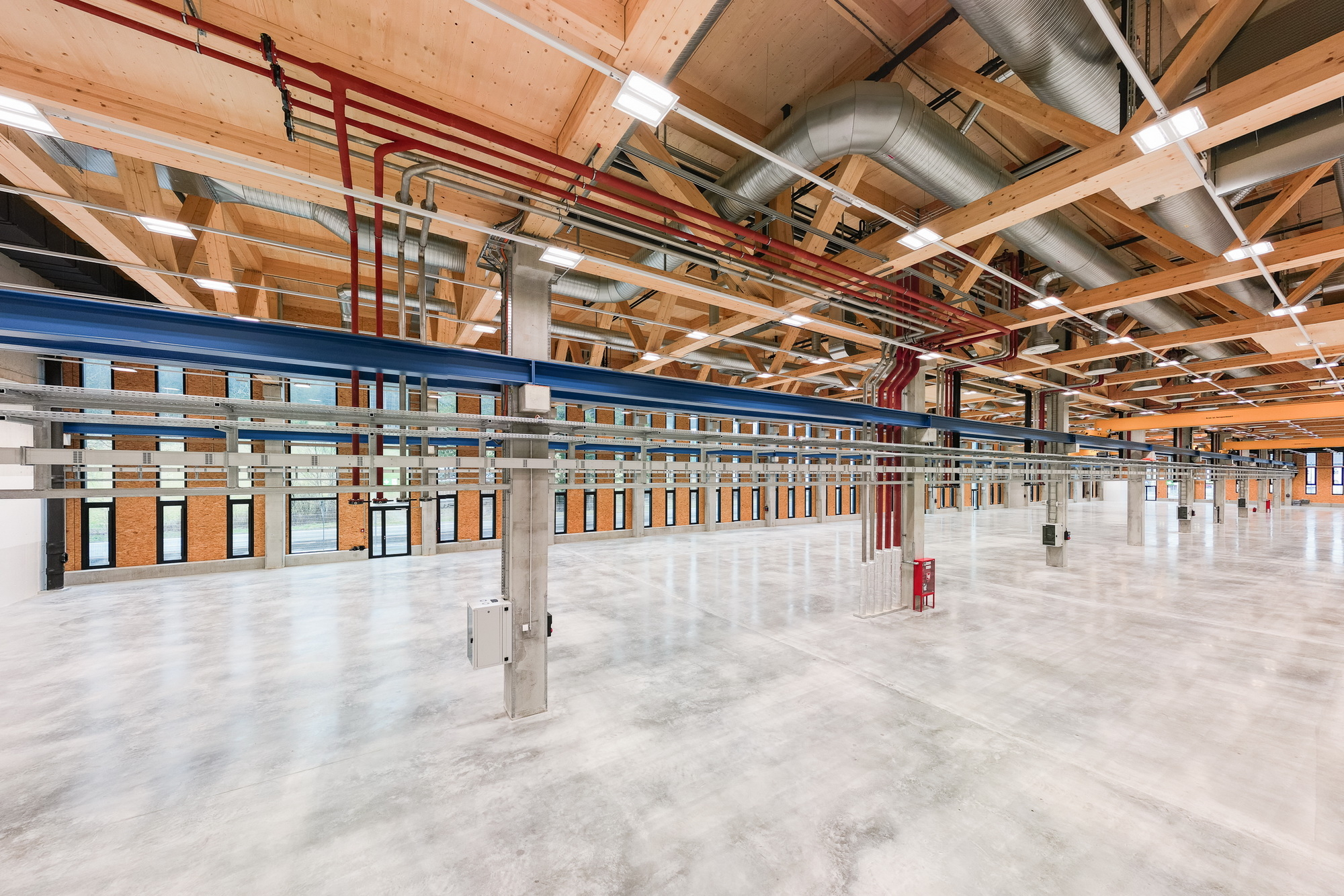 Innen befinden sich sieben großzügige Produktionshallen, das Tragwerk besteht zum Großteil aus reinen Holzbauteilen.