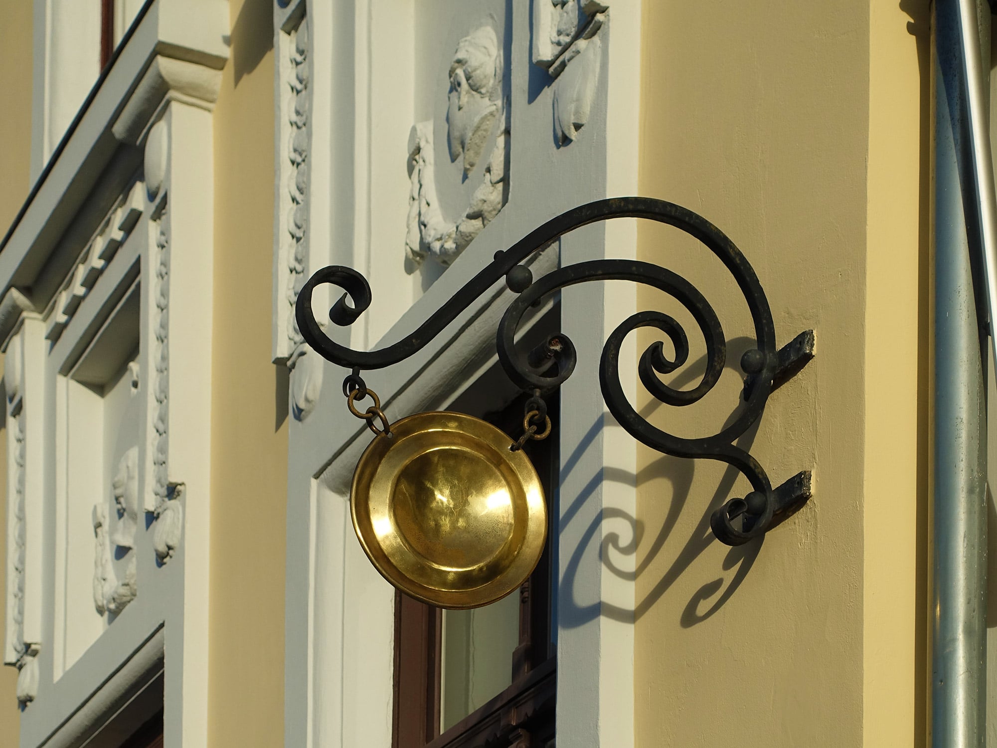 Zunftzeichen sind Schilder mit Symbolen im Sinne von zeichenhaften, bildlichen Verweisen auf eine Funktion oder Dienstleistung. Im Bild: Ausleger mit einem goldenen Teller als Symbol für einen Frisörsalon