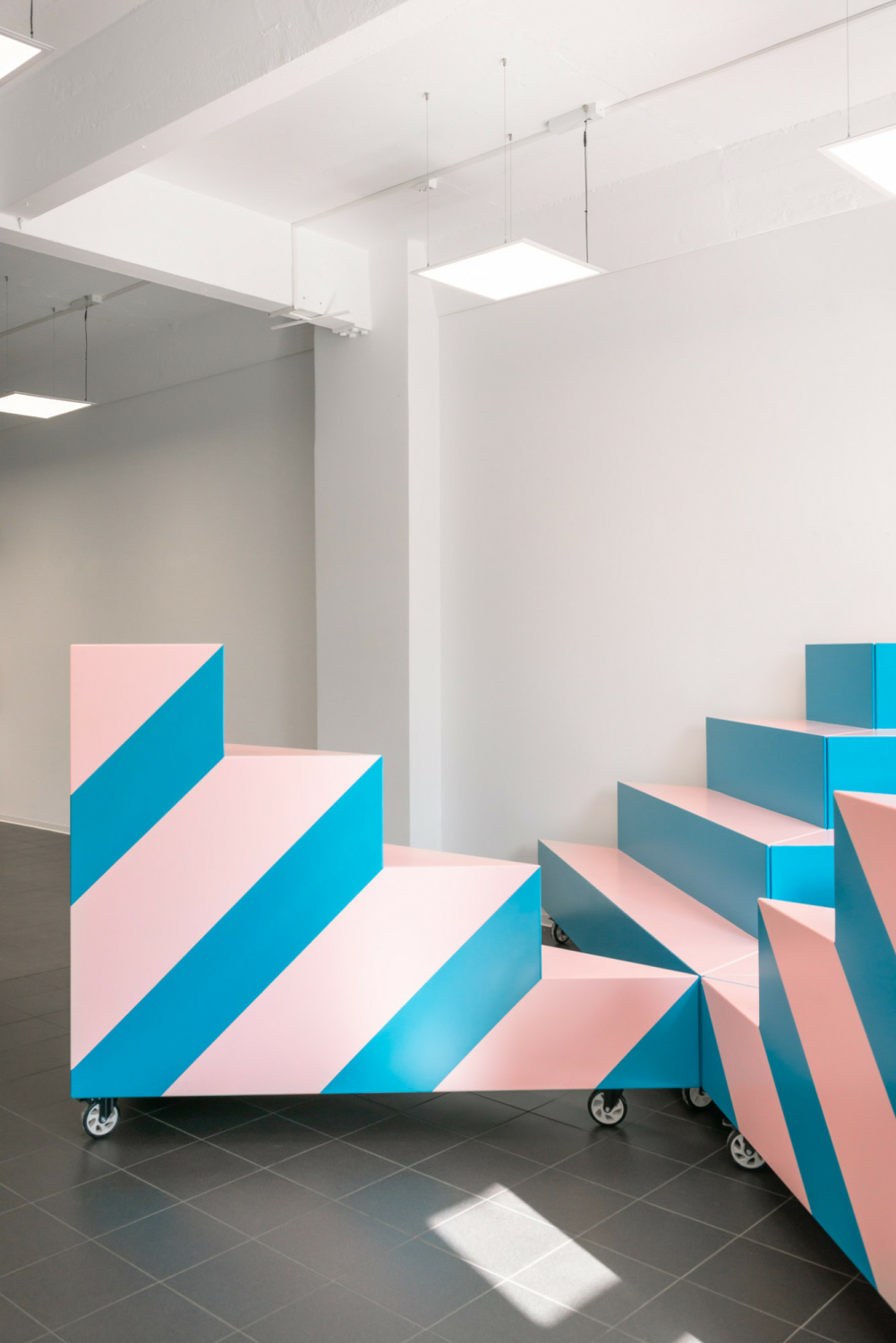 Breite Streifen in Rosa und Blau lassen die Möbel fast schon zweidimensional wirken.