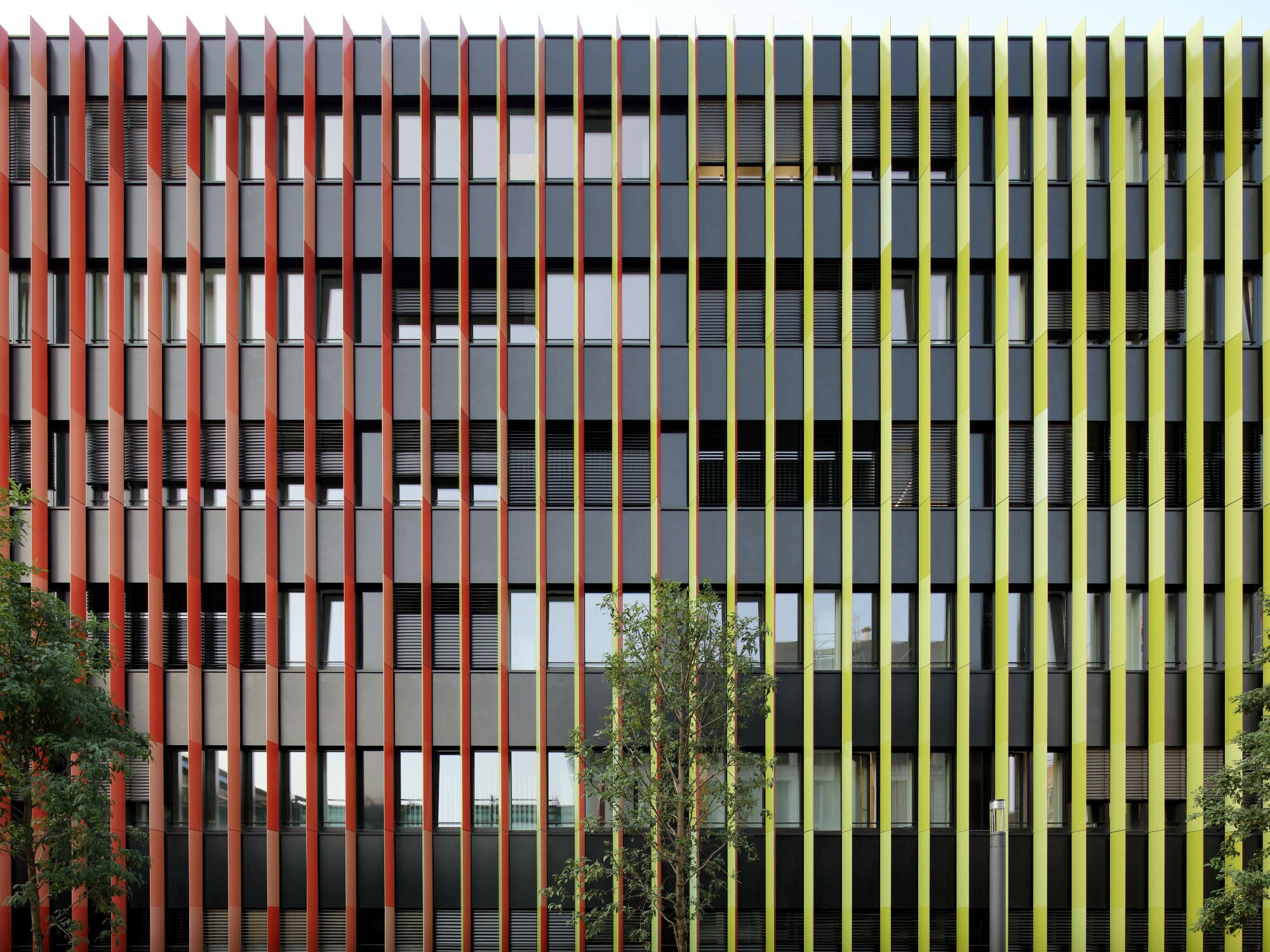 Um ein einprägsames Erscheinungsbild zu schaffen, entwickelte das Büro Kadawittfeldarchitektur eine rotgrüne Lamellenfassade.