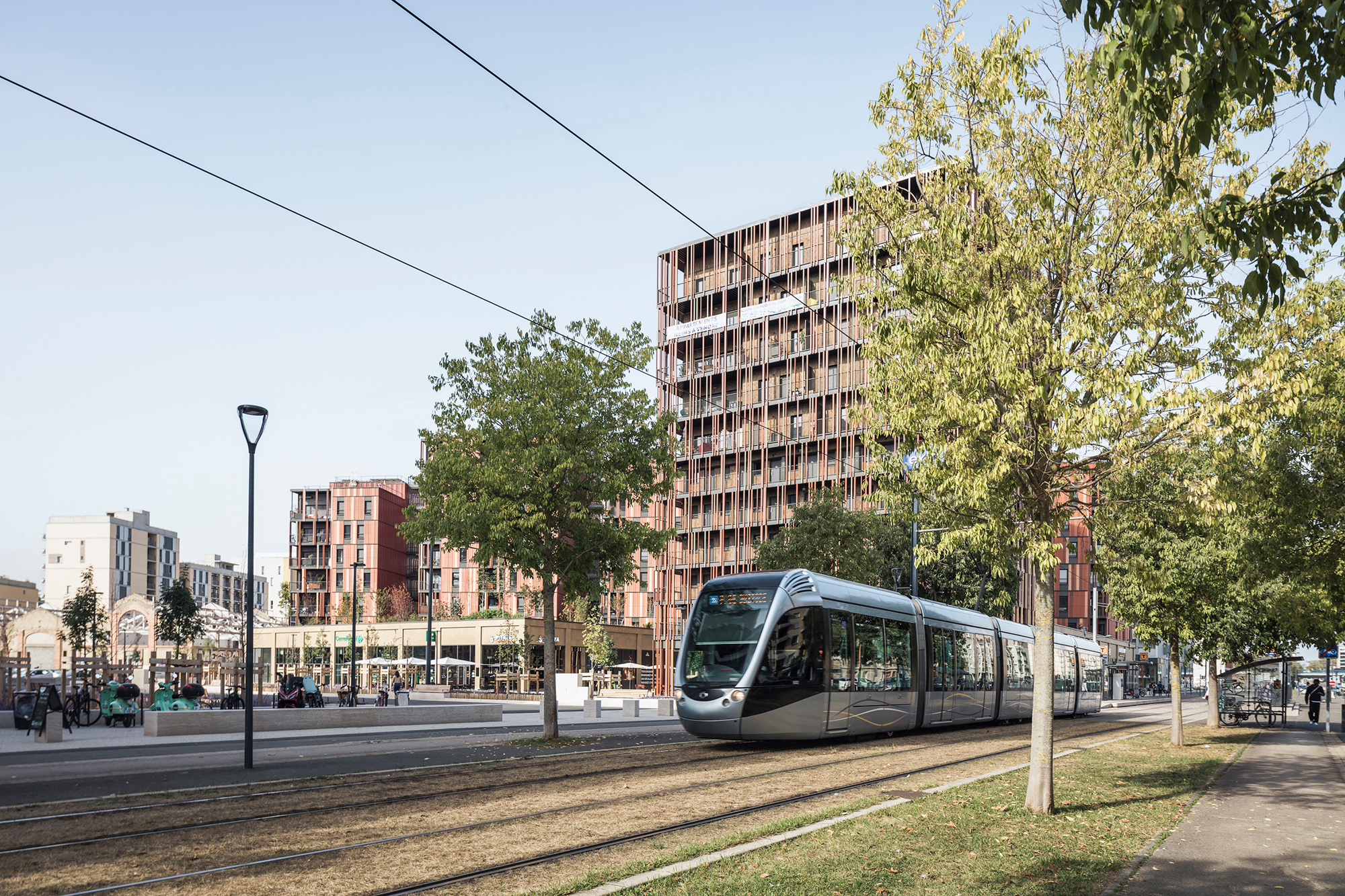Dietrich Untertrifaller Architekten planten das Ensemble, äußerlich zusammengehalten durch eine vorgehängte Fassade aus rötlichen Terrakotta-Platten.