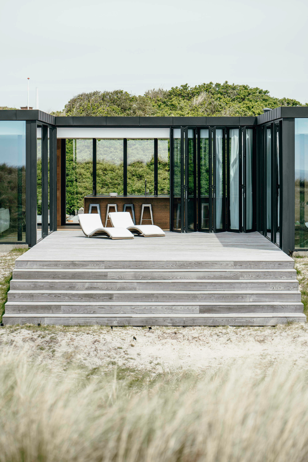 Eine Terrasse mit breiten Stufen in die Dünenlandschaft lädt zum Verweilen ein.