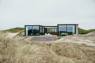 Der geduckte Neubau ist zwischen den Dünen versteckt und gut vor Wind und Wetter geschützt.