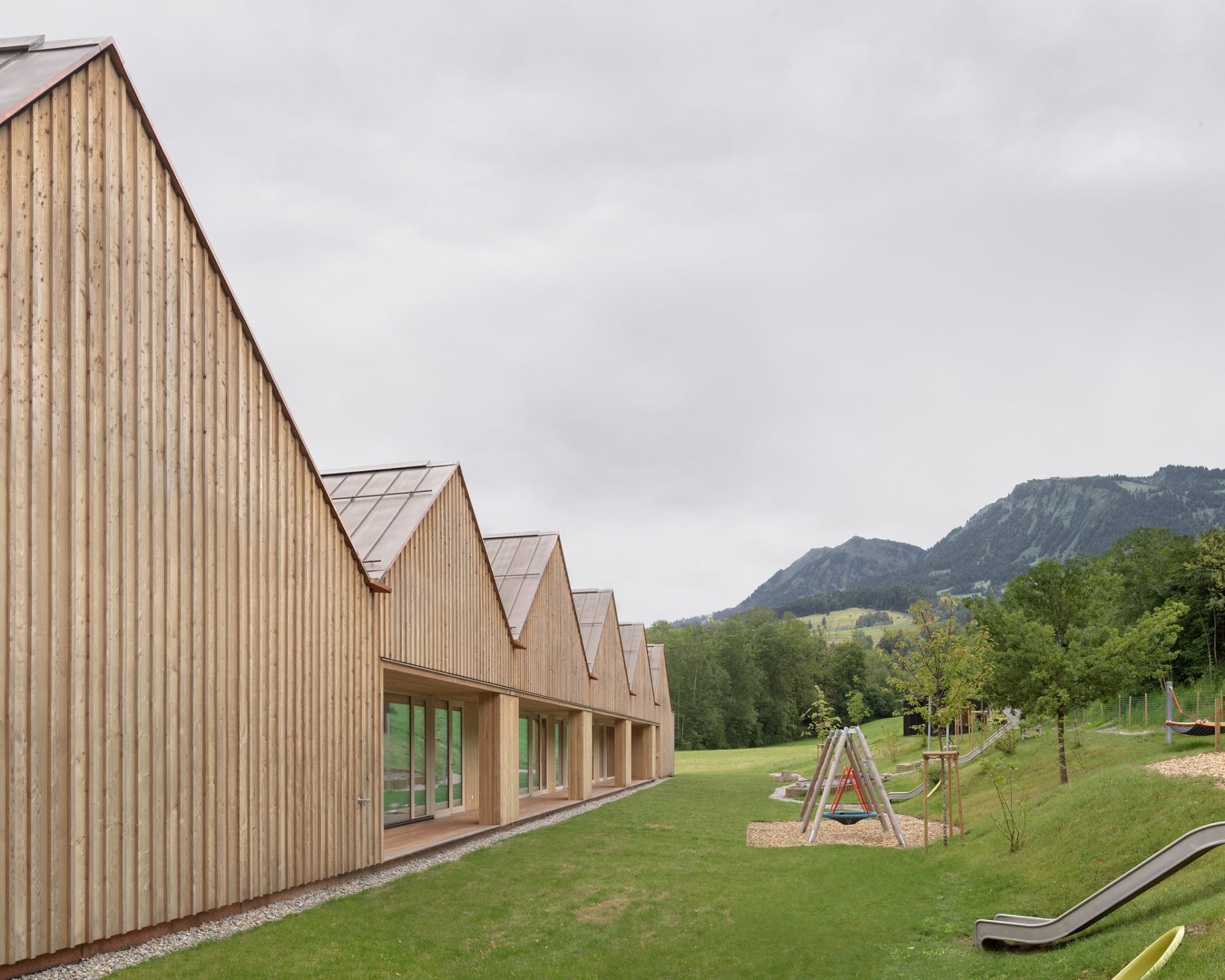 Lärchenholzfassade und Kupferblechdach: Südlich vom „Kinderhaus im Park” befinden sich weitläufige Außenspielflächen.