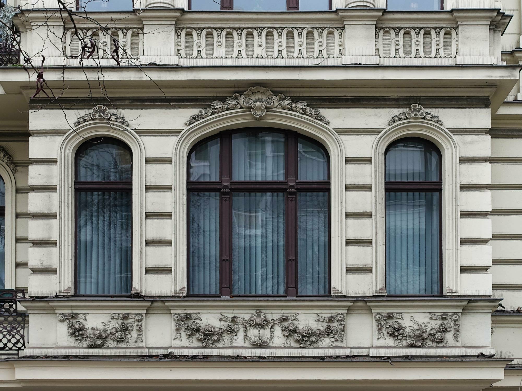 An Portalen, Eingangstüren und Fenstern der Bel Etage ist häufig eine Verzierung zu entdecken, bei der Blätter, Blumen, Blüten, Früchte und Bänder mit Schleifen eine Girlande bilden. 