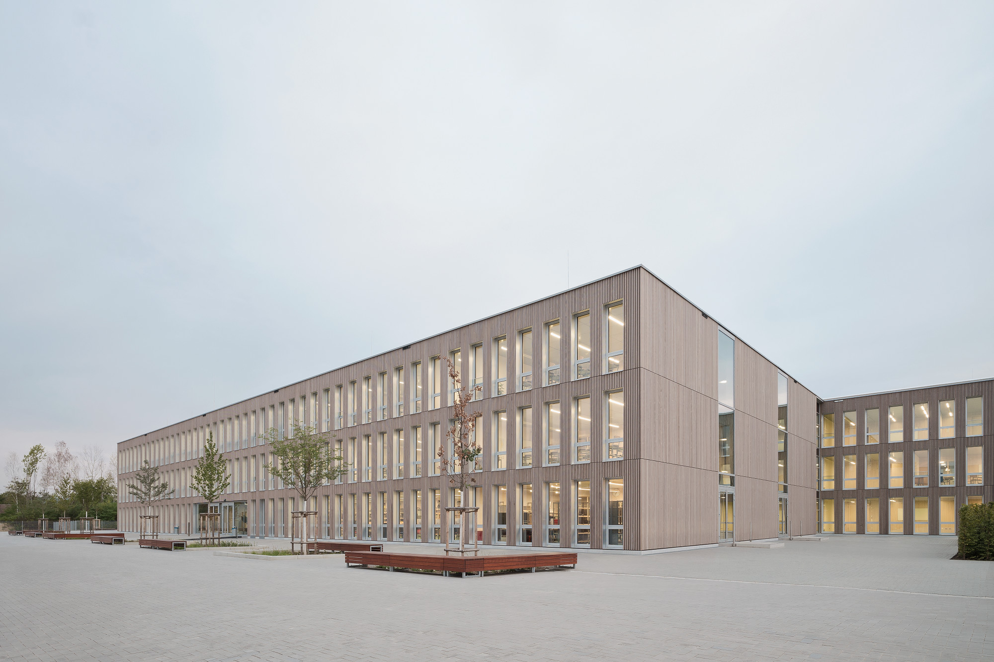 Die Fassade aus vorvergrauten Weißtannenholzleisten ist gegliedert durch schmale, rhythmisch angeordnete Fenster.