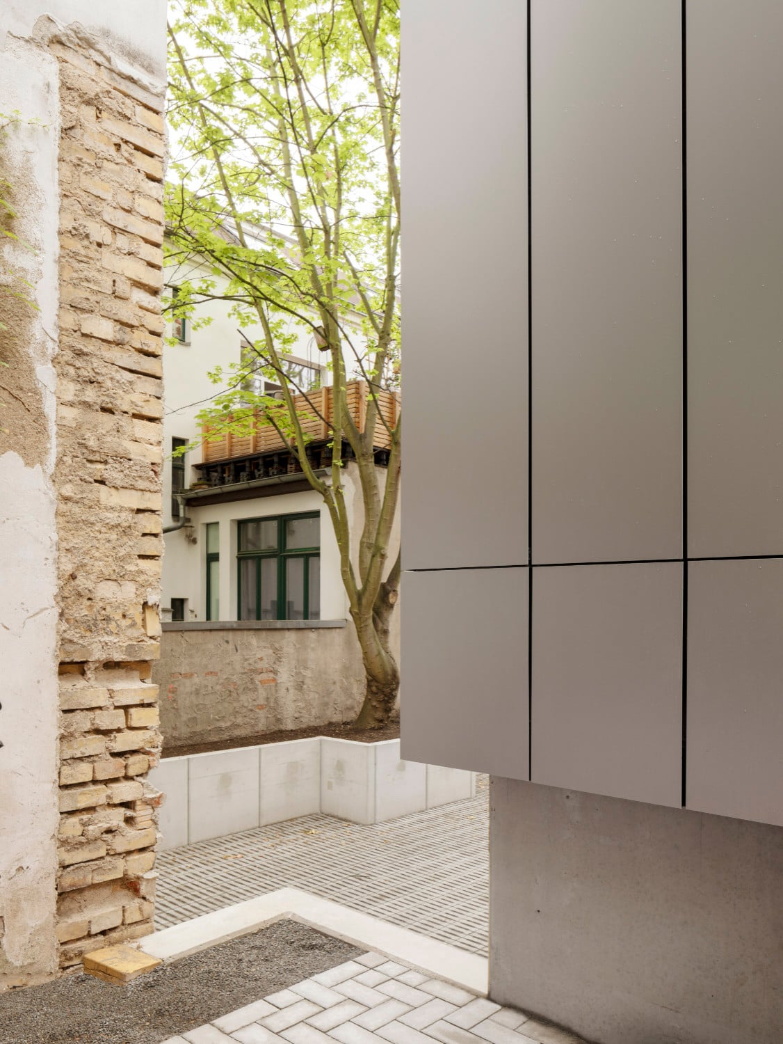Moderne Metallfassade im Kontrast zum historischen Mauerwerk der Gründerzeit