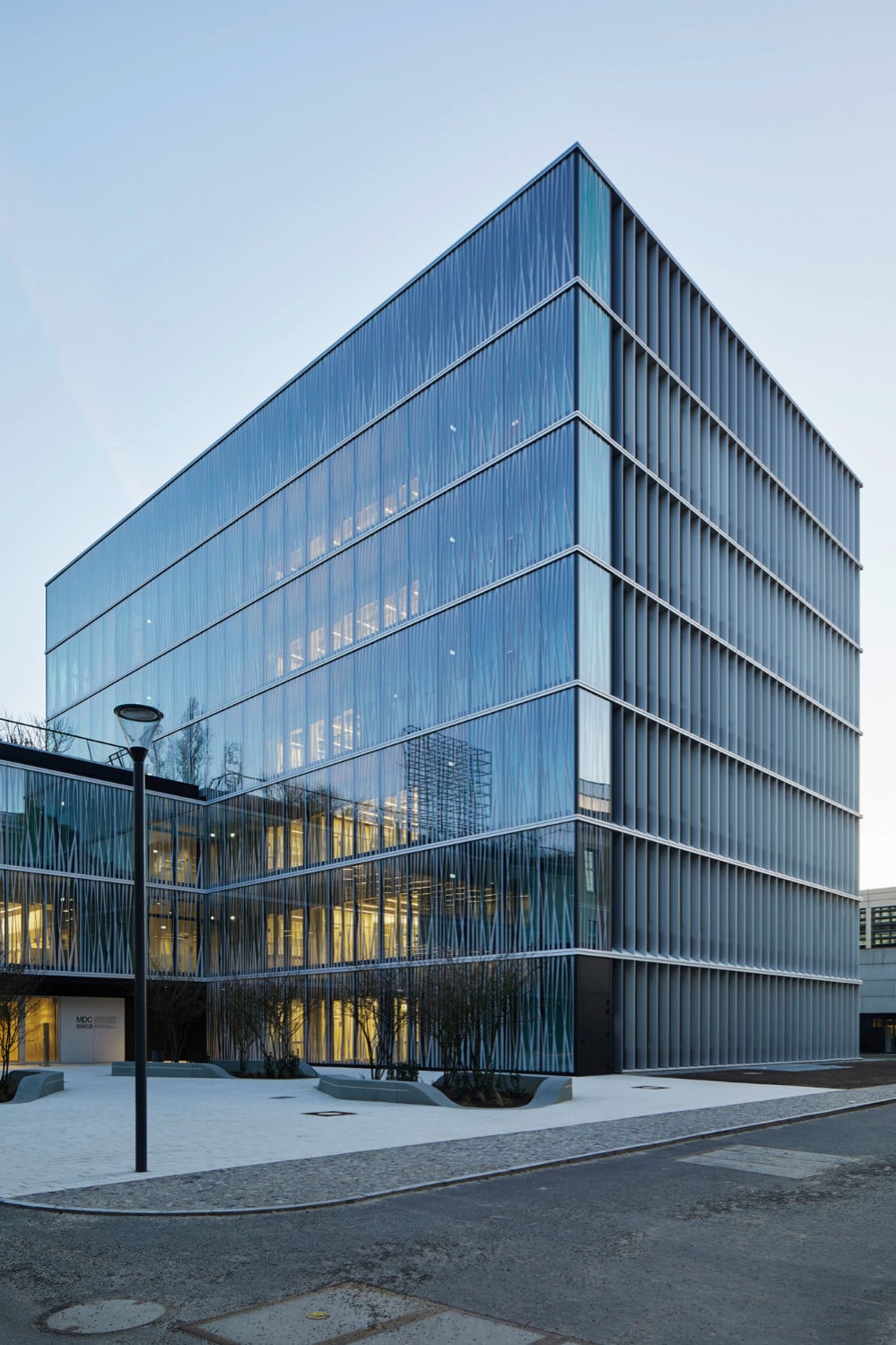 Staab Architekten entwarfen das Laborgebäude mit bedruckter Glasfassade und einem L-förmigen Grundriss.