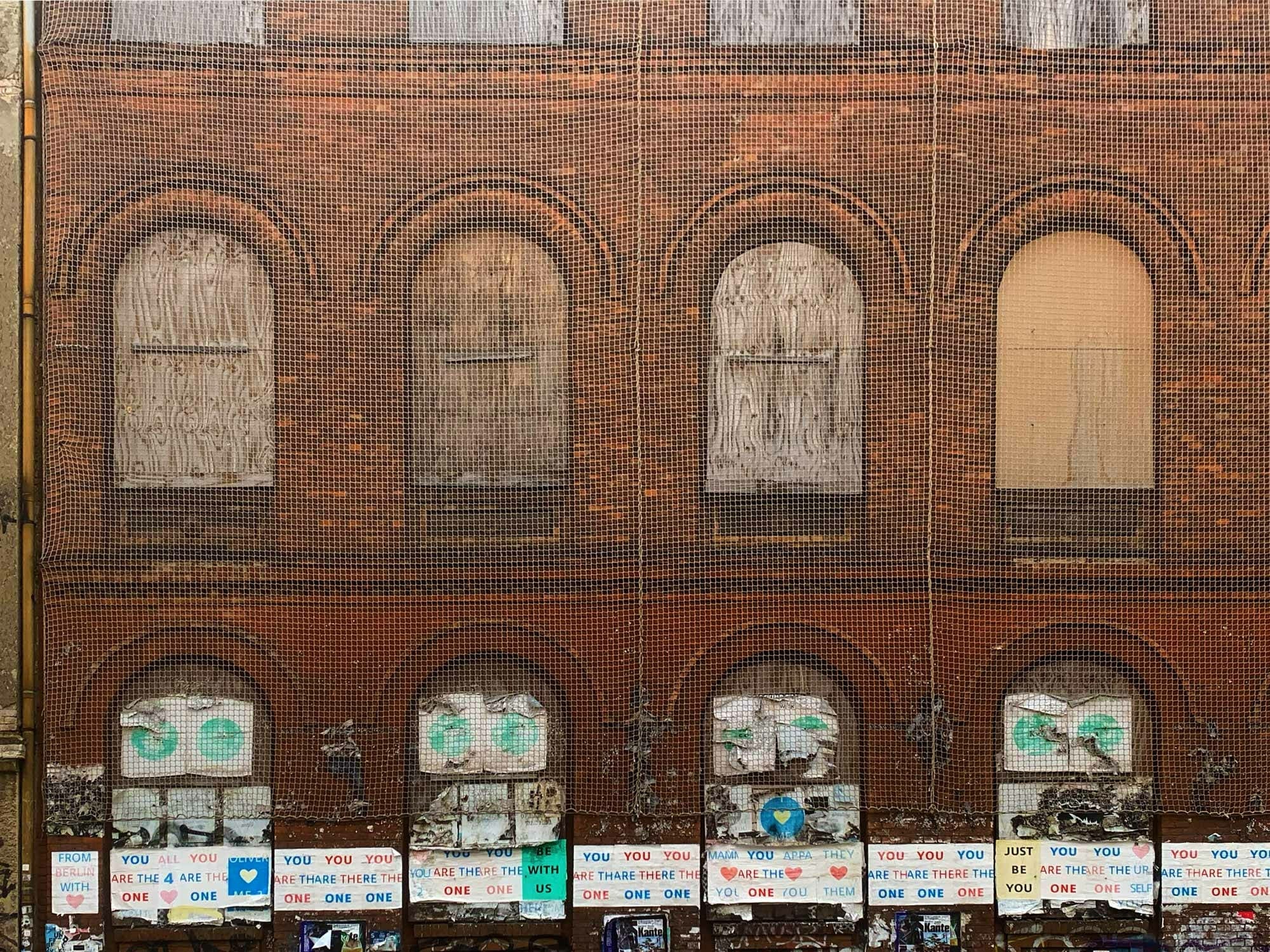 Je nach Eigenart der Materialien kann Materialermüdung zu verschiedenen Schäden führen. Im Bild: Durch Sicherungsnetze geschützte schadhafte Fassade in der Auguststraße, Berlin