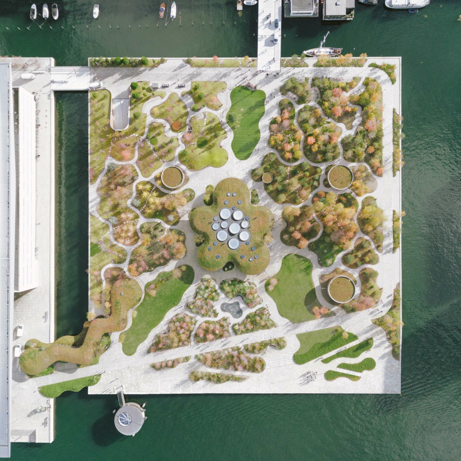Aufsicht: Die ehemals industriell genutzte Insel im Innenhafen neben dem Opernhaus ist heute eine Wald- und Gartenlandschaft mit einem zentralen Gewächshaus und Cafe.