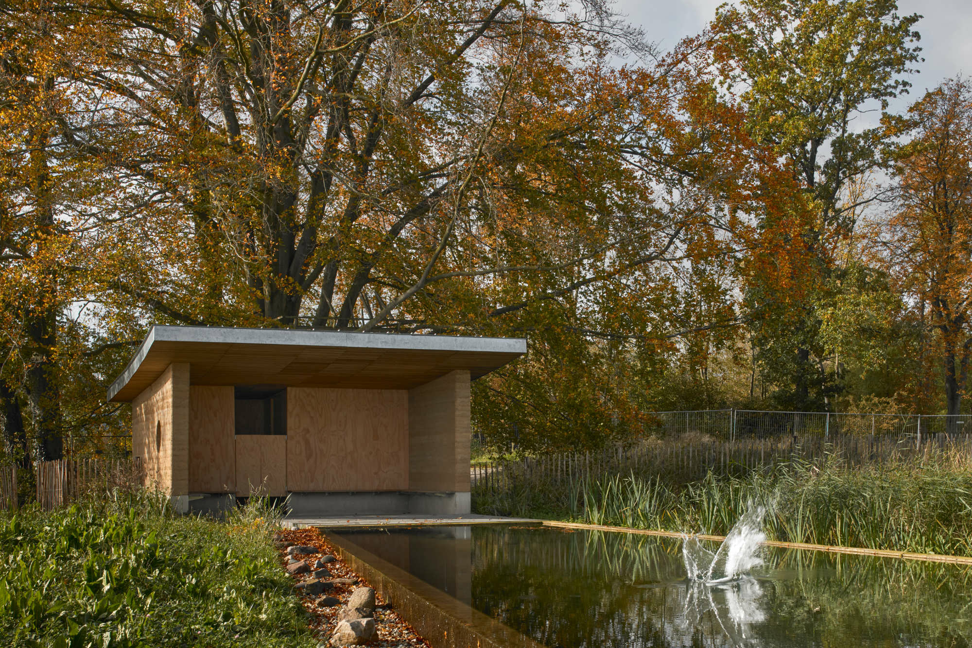 Drei Stampflehmwände formen das Badehaus, in dem sich Umkleideräume befinden.