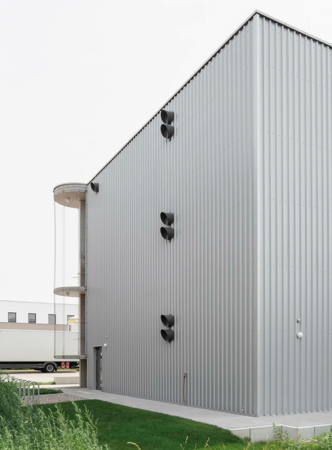 Die geschossweise Be- und Entlüftung ist an der Nordfassade deutlich sichtbar, was zusätzlich den industriellen Charakter des Gebäudes betont.