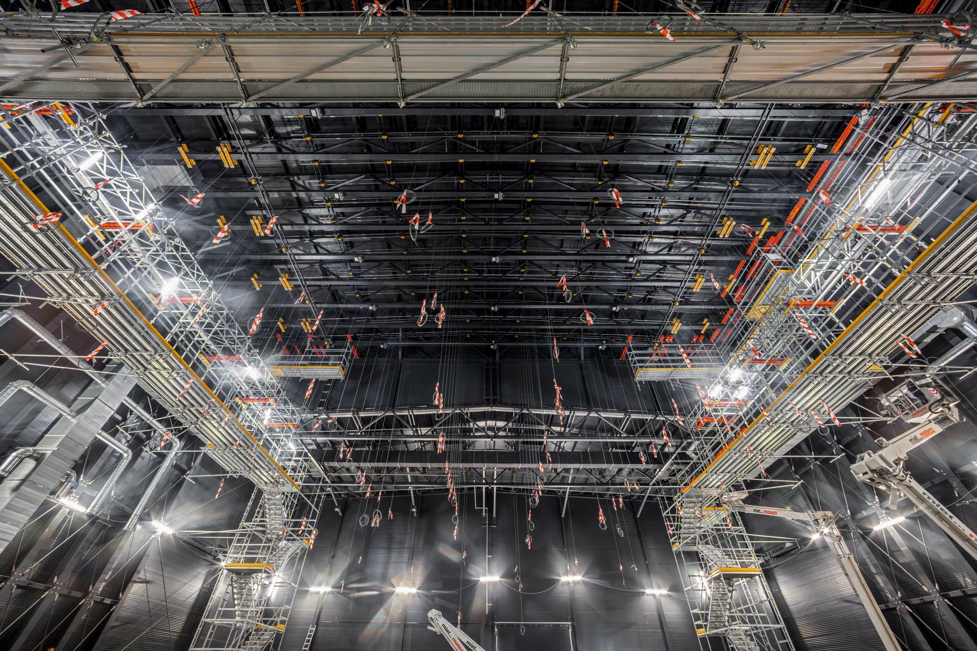 Im Bühnenraum sind die Gerüststege des Systems Peri Up von der Dachkonstruktion der Leichtbauhalle abgehängt.