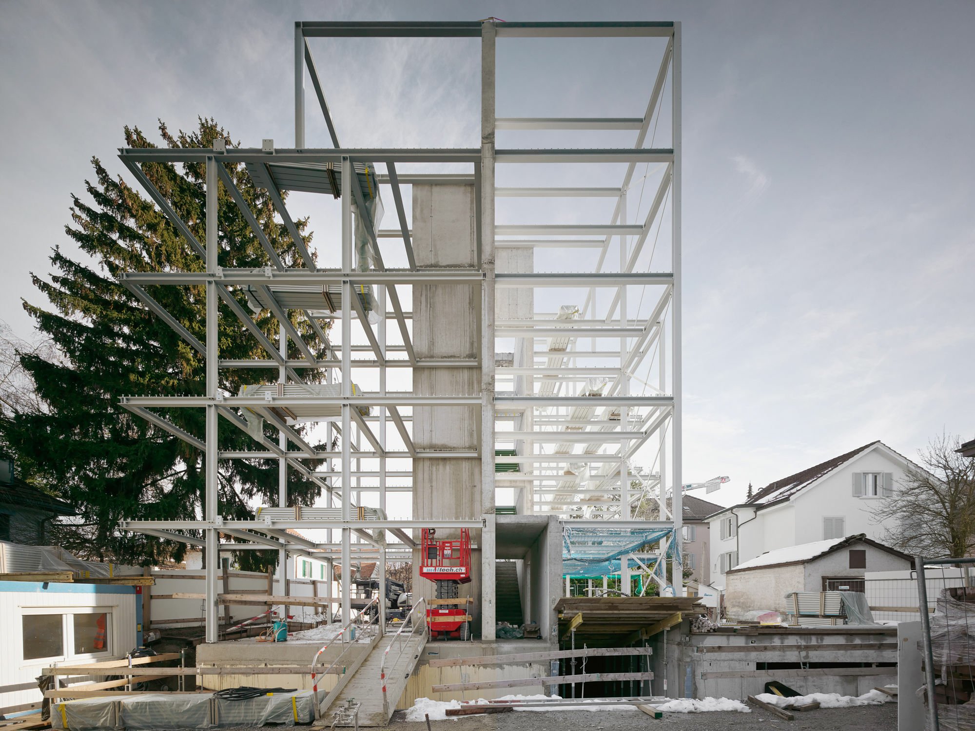 Der fünfgeschossige Neubau steht im Züricher Stadtquartier Oerlikon auf einem 690 Quadratmeter großen Grundstück, das in zwei Parzellen geteilt ist.